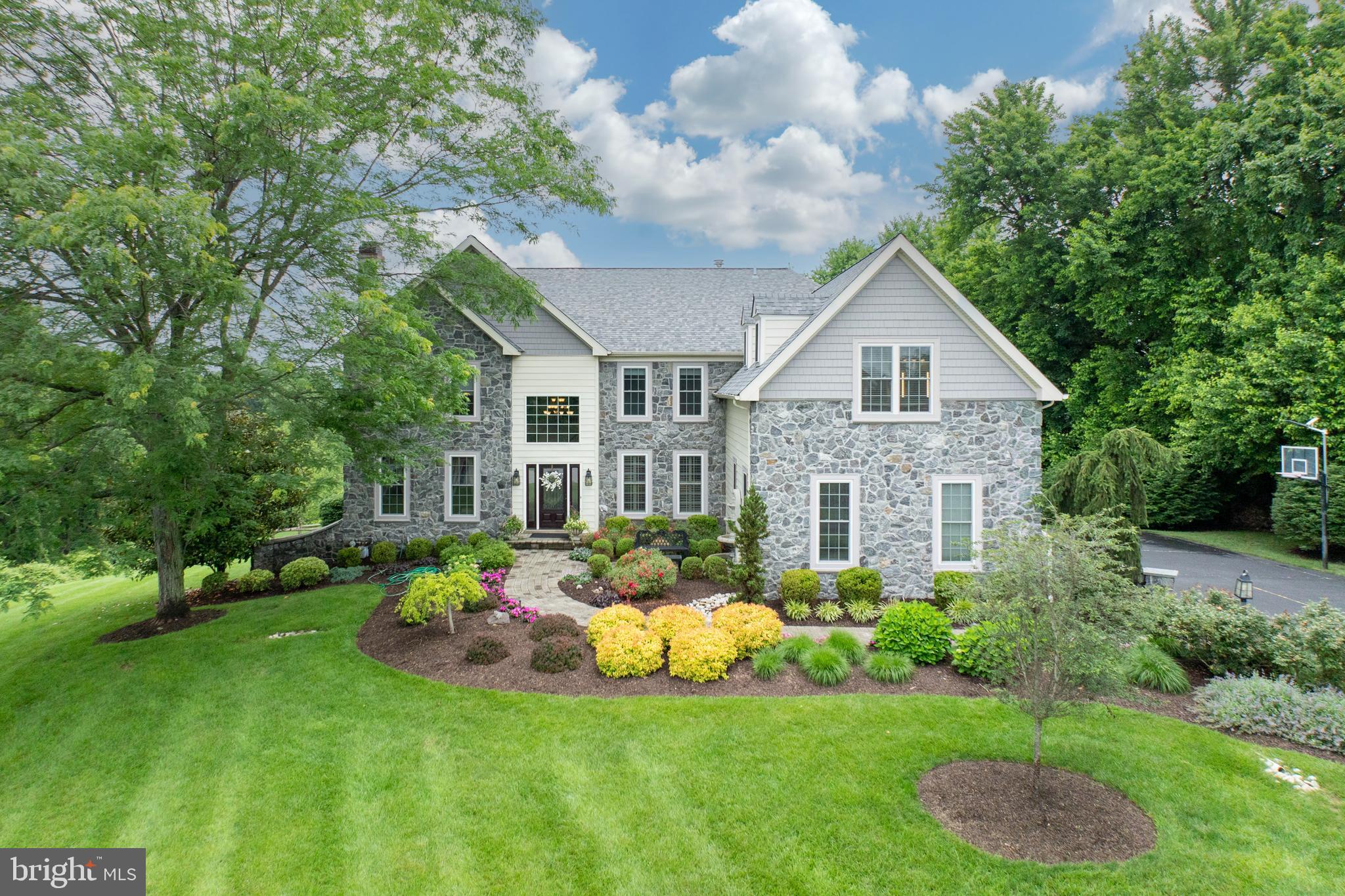 Welcome to 893 Glendale Lane.
Tucked at the end of a quiet cul-de-sac in the sought-after Marshallton Chase community, this exquisite residence offers over 5,500 square feet of beautifully updated living space, picturesque surroundings, and access to the award-winning West Chester School District.
From the moment you arrive, the curb appeal is undeniable, with a beautifully landscaped front yard, charming walkway, and tranquil fountain welcoming you home. Step inside the dramatic two-story foyer where gleaming hardwood floors flow throughout the main level, setting a warm and elegant tone. Pride of ownership is evident throughout, with thoughtful updates and meticulous care at every turn.
To the left, the formal living room features a gas fireplace and crown molding, while the adjacent dining room, currently used as a stylish entertainment lounge, boasts hand-painted walls and detailed trim. The heart of the home is the gourmet, farmhouse-style kitchen, a chef’s dream outfitted with a 6-burner Wolf cooktop, hood, double wall ovens, a wine fridge, leathered granite countertops, a large walk-in pantry, and off-white cabinetry. The oversized island, topped with quartz, features a built-in microwave, while a copper sink set beneath a skylight adds a touch of rustic charm.
The kitchen flows into a sunny dining area and an impressive two-story family room with a wall of windows that overlook the lush backyard and rolling Chester County landscape. A cozy wood-burning fireplace and a second staircase add both functionality and flair. The main level also includes a private office with glass doors, a powder room, a spacious laundry room, and a mudroom with access to the 3-car garage. Two sets of doors, one from the family room and one from the dining area, lead to a maintenance-free deck, perfect for enjoying peaceful mornings or hosting guests.
Upstairs, double doors open to the luxurious primary suite featuring tray ceilings, a separate sitting area, two walk-in closets, and a spacious en suite bath with dual vanities, a jetted soaking tub, a water closet, and an oversized walk-in shower. A second bedroom serves as a princess suite with its own full bath and walk-in closet. Two additional bedrooms, each with walk-in closets, share a Jack-and-Jill bathroom with a dual vanity and tub/shower combo.
The finished walk-out lower level is an entertainer’s dream with a large recreation area, a custom wet bar, a half bath, and generous storage space. The 1.1-acre lot is beautifully maintained and includes room for a vegetable garden and plenty of outdoor enjoyment.
This home has been thoughtfully updated over the years. Notable improvements include stucco remediation on the front of the house with new stone and siding, along with a new roof, front door, and front windows, all completed in 2018. The kitchen was fully renovated in 2019, the driveway replaced in 2021, and new garage doors and openers were added in 2024.
Located just minutes from West Chester Borough with its vibrant restaurants, shops, and convenient access to major routes, 893 Glendale Lane is a rare opportunity to own a move-in ready home in one of Chester County’s most desirable neighborhoods.