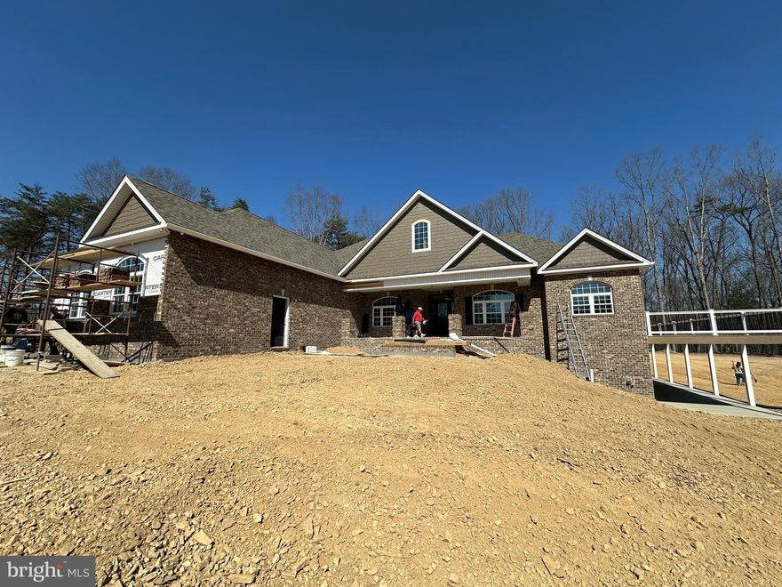 4-6-26 Cabinets in. Painted,, trimmed, and hardwood floors stained and finished.   Getting close.   Delivery estimated April.
At front of  Keplinger Estates near the Apple Pie Ridge area.
Seize a truly unique opportunity to own a brand-new, luxury estate set on over 7 acres of private, wooded land. While this stunning property sits at the entrance to the prestigious, upper-scale 15-lot Keplinger Estates community, it does not have HOA, offering unparalleled freedom and privacy.
Tucked gracefully off the main road, this secluded retreat provides a peaceful, close-to-town setting without compromising on tranquility and space.
Experience the pinnacle of single-level living in this immaculate residence, meticulously designed with a flowing 3,100 sq. ft. open floor plan. The builder has redefined "standard features," integrating premium elements throughout the home that others typically label as costly upgrades.
Key Features & Elegant Finishes:
Striking Curb Appeal: A distinguished full brick front complemented by durable cement siding creates a timeless exterior, highlighted by a large, welcoming concrete front porch and lead walk.
Exquisite Main Level: Rich, stained Early American hardwood flooring flows seamlessly across the entire main level, excluding the elegant tiled bathrooms and laundry room, creating a warm, inviting atmosphere.
Expansive Indoor/Outdoor Living: The home is designed for seamless entertaining and relaxation, featuring an extensive covered and screened deck that connects to open deck that wraps around the entire right side of the house.  Full patio under covered and open decks.
Walk-Out Access & Patio: The basement boasts convenient double-door walk-out access, opening onto a full-length concrete patio that extends from the breakfast room and continues beneath the expansive side deck.
Construction Update: Selections to be as depicted in example photos. Inquire to view this builder's impressive list of standard features.