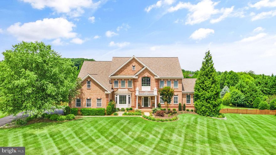 DREAM HOME WITH A SALTWATER POOL! This magnificent Stanley Martin built 'Leighton' home is a true masterpiece, situated on an exceptional 3.63-acre leveled lot that offers the perfect blend of privacy, serenity, and breathtaking views from every window. This distinctive home boasts over 6500+ square feet of well-designed living space with an open floor plan that includes abundant windows, light-filled living areas, dramatic ceilings, and luxurious details such as gleaming hardwood flooring, recessed lighting, arched entryways, and crown molding. You'll love coming home to this beautiful house with great curb appeal, featuring a handsome brick front entrance, covered portico, and a lush front lawn. Welcome friends and family into the inviting foyer with a striking butterfly Oak staircase that provides sweeping views of the main living areas. The main floor offers a formal living room with plantation shutters flowing into the side conservatory with large windows, a vaulted ceiling, and lovely garden views. Additionally, there is a spacious separate dining room with a bay window, perfect for entertaining, and a study room. 
The home boasts a lovely two-story family room with a gas fireplace and a wall of windows, seamlessly opening to the heart of the home – the gourmet kitchen. The chef's dream kitchen features upgraded cabinetry, granite countertops, an oversized island with a breakfast bar, gas cooktop, double oven, large pantry, and a charming breakfast area. A mudroom and a separate laundry room off the kitchen add convenience to your daily life. A secondary staircase conveniently leads from the family room to the upper level, with hardwood floors in the landing and a cozy reading nook facing the front of the home. The primary bedroom suite is a true retreat, featuring a tray ceiling, a 3-sided gas fireplace, an oversized walk-in closet, a private sitting room/den, and a luxurious bath with dual vanities, separate shower, and a soaking tub. There is an additional secondary bedroom with a private en-suite bath, as well as two more bedrooms with a shared bathroom featuring dual vanities. Rest or play in the well-designed walk-out lower level offering plenty of natural light, a spacious recreation room with a newly added GORGEOUS 2ND KITCHEN, full bath, a large media/game room, an exercise room (5th bedroom), and ample storage space. Step outside to your own piece of paradise in the leveled and fenced backyard, complete with a saltwater pool, hot tub, a generously sized and upgraded Ipe deck, a large patio, and beautiful landscaping. It's the perfect space for playing ball, grilling, chilling, and living your best life. Additional features include a 3-car side garage with upgraded flooring and cabinets, a long driveway, and recent improvements such as a new roof in 2019, upper HVAC in 2022, and conservatory HVAC in 2020. The home is nestled in the tucked-away Glynn Tara Estates community, close to shopping, dining, and entertainment options in Downtown Leesburg, Lucketts, and many local wineries and breweries. Easy access to major commuter routes adds to the convenience and beauty of this home and Loudoun County living! SEE VIRTUAL TOUR & FLOORPLAN, SELLER PREFERS COMMUNITY TITLE