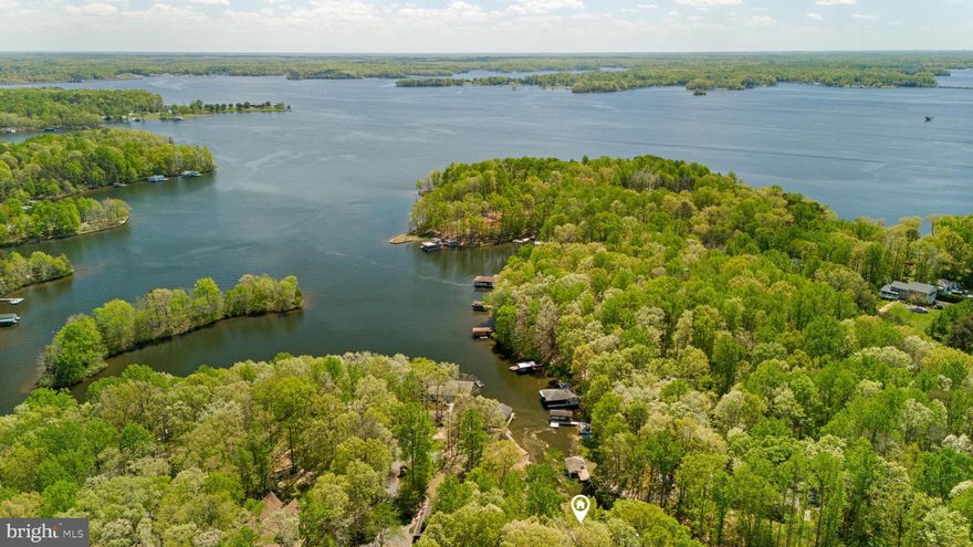 Price adjustment! This stunning waterfront lot, located slightly south of mid-lake on the public side of Lake Anna, offers an incredible opportunity to enjoy lake life this summer while you plan the lake home of your dreams. With 100 feet of private shoreline, the property includes a covered boat dock equipped with an electric lift, sunning area, and a screened-in seating space—perfect for relaxing by the water or entertaining guests. The lot already has electric in place and is perced for a conventional septic system, making it ready for your custom build, whether as a full-time residence or a weekend getaway. Surrounded by mature hardwoods, the property offers both privacy and beautiful lake views. Located in the desirable Blounts Harbour subdivision, you'll enjoy the peacefulness of nature, abundant wildlife, and direct access to all that Lake Anna has to offer.