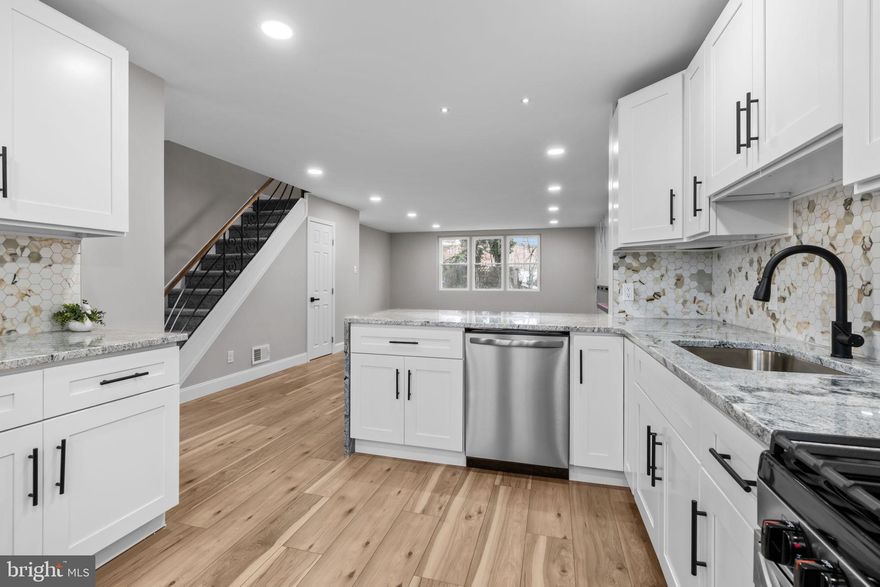 Welcome to this beautifully fully renovated end-unit townhouse located in the desirable Ashton–Woodenbridge neighborhood of Philadelphia. This home offers modern design, luxury finishes, and exceptional functionality. Step into a bright open-concept layout featuring a brand-new white kitchen with sleek cabinetry, modern granite countertops, and a large island with a waterfall stone edge. The kitchen is complete with all-new stainless steel appliances, perfect for both everyday living and entertaining. Throughout the home, enjoy new modern laminate flooring, high ceilings, and recessed spotlights that enhance the airy feel. The living room is a true showstopper, highlighted by a huge electric fireplace with multi-color LED lighting, beautifully set against a full marble accent wall. The home offers three spacious bedrooms and modern upgraded bathrooms. The fully finished basement includes a large living area and an additional room that can easily be used as a fourth bedroom, office, or guest suite. The basement also features separate entrances from both the front and the back of the home, offering excellent flexibility for guests, extended family, or potential in-law use. Major system upgrades include: HVAC system and water heater only 2 years old, Brand-new AC condenser, All brand-new windows.  Conveniently located near major shopping centers, US highways, and everyday amenities, this move-in-ready home delivers the perfect blend of style, comfort, and location.  A must-see—schedule your private showing today!