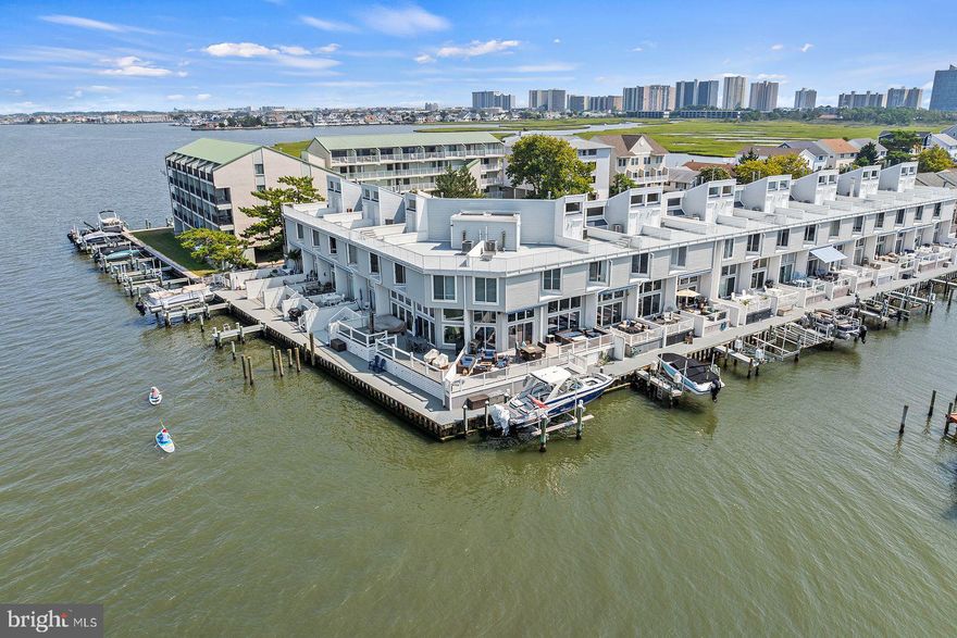 Welcome to your perfect waterfront retreat! This beautifully furnished Bayfront Townhouse offers 3 spacious bedrooms and 2.5 modern baths, ideal for both relaxation and entertaining. Enjoy the convenience of a boat dock with a lift, making water adventures effortlessly accessible. The large bayfront deck, complete with an electric awning, provides a stunning outdoor space to soak in the views and enjoy the tranquil setting. For panoramic vistas, head to the rooftop deck, which faces southwest for breathtaking sunsets. Located at the quiet end of 94th Street in a serene cul-de-sac, this home is just a short stroll from popular restaurants and shopping, combining peaceful living with convenient access to local amenities.
