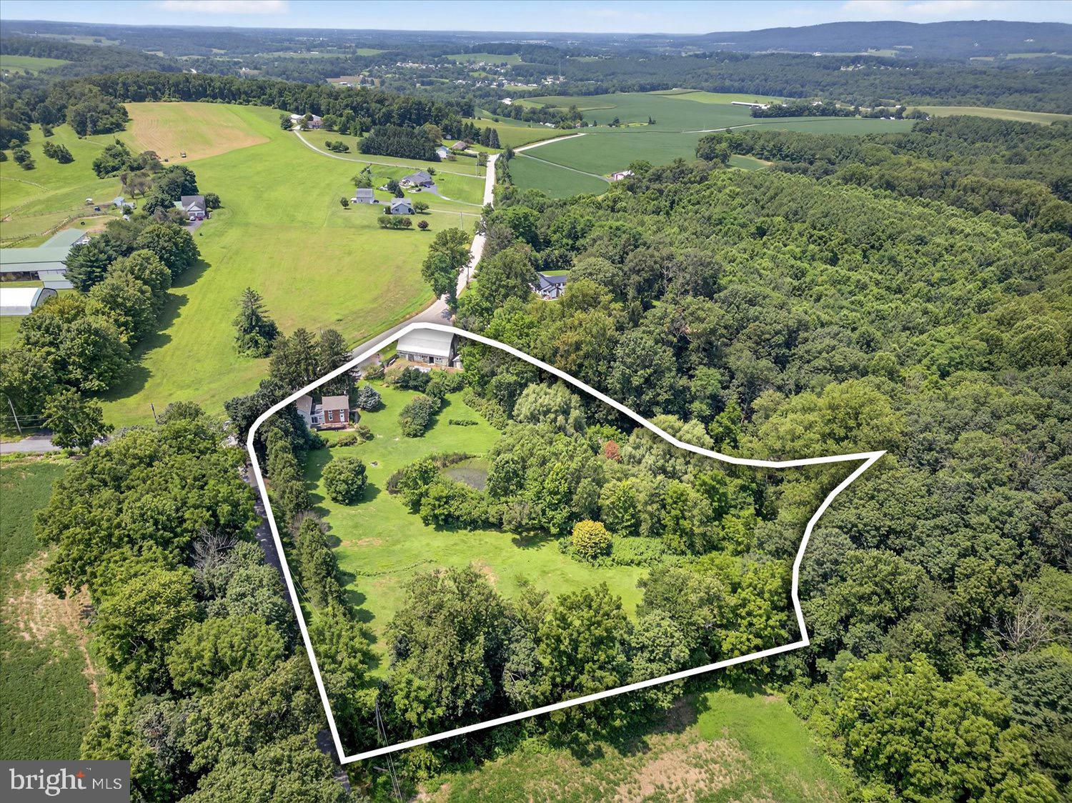 Welcome to this charming farmhouse retreat, perfectly set on 3.77 picturesque acres with a serene spring-fed pond. As you approach, a tree-lined road creates an elegant, storybook setting leading to the property. The home features a private primary bedroom with its own en suite bath, offering a peaceful escape from the rest of the house. There are 3 other very spacious bedroom and an attic space for plenty of storage.
A two-story barn anchors the grounds, surrounded by multiple enclosed gardens ideal for growing flowers, herbs, or vegetables. A sprawling parking area accommodates a dozen cars, with additional access from the rear of the property for convenience. The home’s entrance is tucked away toward the back, providing shade, privacy, and a sense of seclusion.
This home blends charm, functionality, and natural beauty, making it the perfect setting for quiet country living or a versatile homestead.