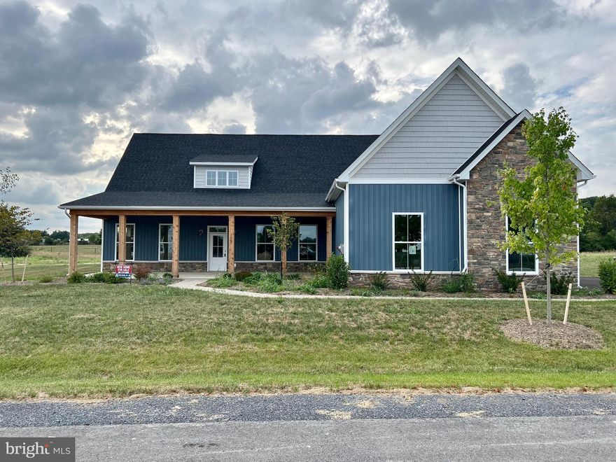 Available Home on 1+ Acre wooded lot. This luxurious community offers dazzling, upscale home styles with 1 acre+ lots and are close to the VA line in Berkeley County. Open up your living space with the Camelia model a spacious 4,500+sqft, 5 bed, 4.5 bath rancher with wainscoting, an open concept floor plan, and 10ft ceilings on the main level. The kitchen shines with upgraded appliances, a Quartz island with a built in cabinet microwave, double ovens, and touchscreen cooktop. The primary bedroom is on the main level and has access to a rear porch. The primary bath boasts a double door bathroom, with huge walk-in double shower, soaking tub, and ceramic tile flooring. You will want to snuggle up with a good book in front of the gas fireplace in the 14x16 sunroom - which has access to both rear porches with ample entertaining space! The upper level of the home is just as large as the main level! There are an additional two bedrooms with their own bath. Entering the upper level, you will find a rec room with wet bar, a storage room, and a quiet sitting area. Other features include recessed lighting throughout the entire home, crown molding, and LVP flooring. On the exterior there are cedar shaker shingles, stone work, 3 car side loading garage, and a 12x40 front porch. Windows line every inch of this home so let the natural light flow through! Schedule your showing today to see what our newest community has to offer!