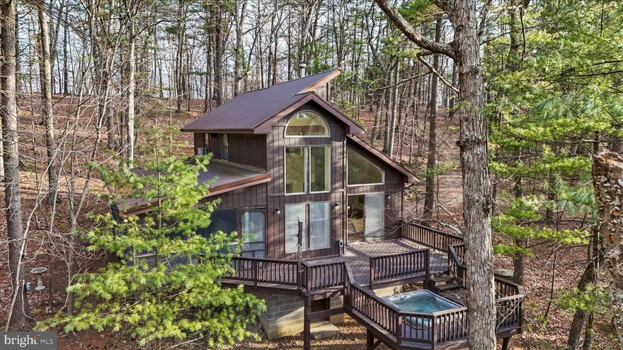 Discover this custom cabin style home tucked away on a tranquil, non-through street and surrounded by a beautifully wooded setting. Offering 2 bedrooms and 1.5 baths, this property blends privacy, character, and rare investment potential. This home features a semi- open floor plan and an  inviting interior with warm contemporary finishes. Relax on the oversized, 15x30 screened-in porch or step out onto the deck, where a sunken hot tub lets you soak in the wooded views year-round. The home features a newer roof, water heater,  well pump and pressure tank, along with an upgraded water filtration system for easy, low-maintenance living.  Anderson windows, a free standing wood stove, and ample storage nooks are some of the custom features, Mark Dawson, a local builder chose when designing the home. This unique offering includes four subdivided (and professionally surveyed) lots sold as a package, totaling just over 20 acres—ideal for future expansion, recreational use, or long-term investment. A truly exceptional opportunity for buyers seeking privacy, acreage, and a distinctive home with room to grow.