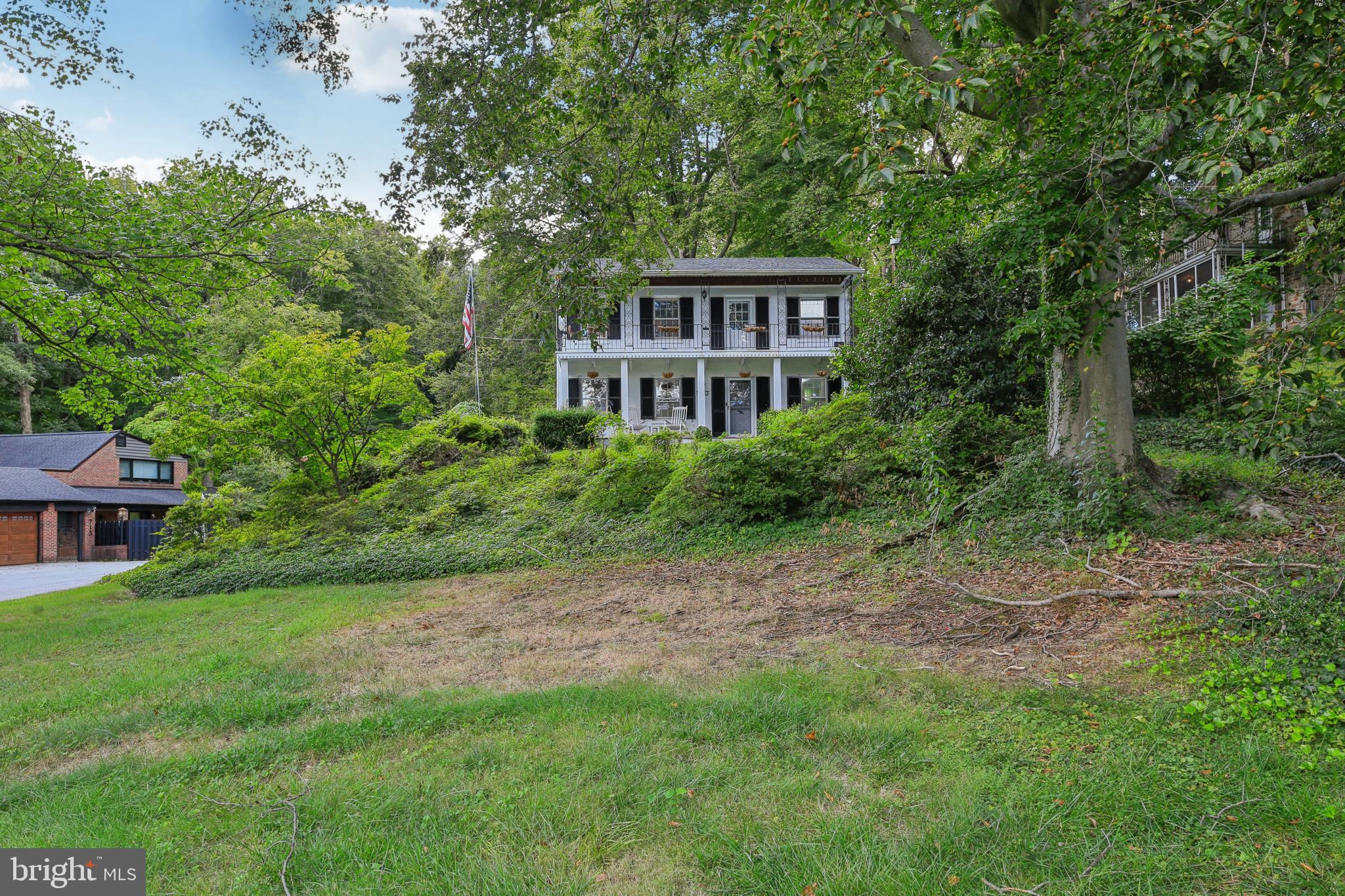 Welcome to 703 Hillen Road, a charming Colonial-style detached home in a prime Towson location. This residence offers three bedrooms, two full bathrooms, and one-half bath with a traditional floor plan. Interior features include a mix of hardwood and carpet flooring, as well as a new HVAC system installed in 2023 for added comfort. The home sits on over an acre of land, highlighted by blooming azaleas and a natural stream at the rear of the property. Outdoor living spaces include a deck and two bedrooms with access to private balconies, providing great spots to enjoy the surrounding views.