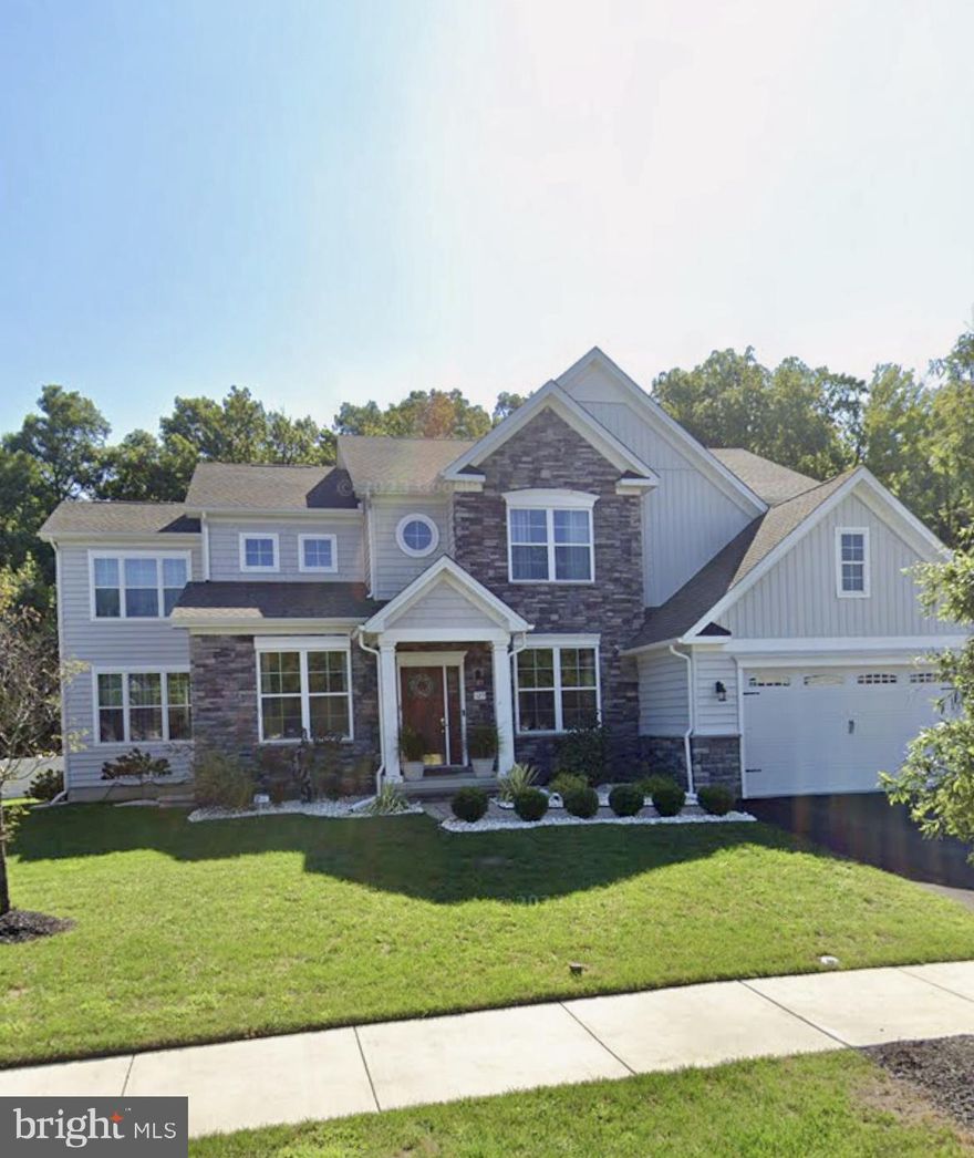 Welcome to the largest home in Meridian Crossing! Masterful design meets modern luxury in this stunning 6-year-old contemporary stone Colonial offering an impressive 6,215 square feet of finished living space. This expansive 5–6 bedroom, 3½-bath home delivers exceptional scale, thoughtful upgrades, and elegant architectural details throughout. From the moment you arrive, curb appeal shines with manicured landscaping, new hardscaping, decorative columns and barn-style two-car garage doors. Inside, natural light pours through walls of windows, illuminating 9-foot ceilings, designer lighting, and rich hardwood and LVP floors that flow seamlessly across every level of this gorgeous home (No carpet!). The formal living and dining rooms showcase classic crown molding, while the breathtaking gourmet kitchen serves as the heart of the home, perfect for entertaining on any scale. Highlights include a 36-inch gas cooktop with pot filler, professional range hood, electric double wall oven, in-drawer microwave, farmhouse sink, side-by-side touchscreen SMART refrigerator, quartz countertops, upgraded white cabinetry with glass uppers, full-wall designer backsplash, butler’s pantry, oversized center island with seating, breakfast bar, and a separate dining area. An adjoining morning room opens to the deck through sliding glass doors, ideal for morning coffee or sunset views, while the centrally located great room invites gathering and relaxation. A stylish powder room, an oversized pantry off the garage that was converted to a second laundry room, complete the main level. Upstairs, retreat to the spacious owner’s suite, featuring two walk-in closets, including a boutique-style dressing room with custom organizers valued at over $10,000 and charming farmhouse doors. The spa-inspired owner’s bath includes a water closet, Jacuzzi whirlpool tub (with a second hot water heater), and a European-style shower. Three additional generously sized bedrooms, a full hall bath, linen closet, and convenient second-floor laundry (two laundry rooms in the house) complete this level. The fully finished basement significantly expands the living space, offering two additional bedrooms (one ideal for a home office), a full bath, exercise room, bar area, and abundant storage, bringing the home’s total finished space to an exceptional 6,215 square feet. The private fenced-in yard backs to wooded open space, enhancing the home’s tranquil setting. Located in the prestigious Meridian Crossing community, residents enjoy low-maintenance living with an association fee that covers lawn care, snow removal, trash service, and access to a luxury clubhouse with pool, fitness center, picnic areas, and movie room. Conveniently located minutes from Route 1 and I-95. This remarkable home offers space, style, and sophistication rarely found—schedule your private tour today.