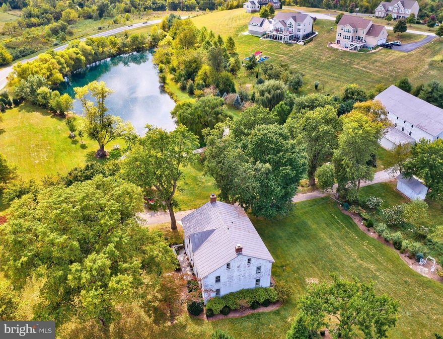 Stunning, one-of-a-kind versatile property that feels like you are on vacation every day! Historic stone/brick home built in the 1800s has the most beautiful wide-plank hardwood and period features. Stocked pond, gazebo, large barn, and picturesque well-house all add to this romantic setting. 
7 Acres of beauty! Enjoy a swim in your own pond or an afternoon of fishing. Home boasts almost 4,000 sq ft of living area. First floor features gorgeous dining room, living room, kitchen, family room, half bath and butler's pantry area.  Four large bedrooms upstairs and full bathroom that has been designed to have separate toilet, sink area and shower area. 
Lower level has a large rec room with flagstone flooring installed in 2015 with walkout door to the long, stone side patio  - Lower level also has a bar and stone fireplace with the look and feel of a European Inn. 
Roof re-silvered in 2022, updated 200 amp electric panel & oil boiler renovated in 2021, 2 large above ground oil tanks, electric water heater, Septic new in 1971, tile drain 4 trenches & 1250 gallon septic tank. Drilled well was 1967 219 ft produced 4 1/2 GPM. New gutters & leaf guards after 2014 along with french drain around house foundation. 
Large barn is added feature! Brick paver floor on entire lower level with many stalls. Upper level offers plenty of storage space or a project to convert into usable space. 
Truly a one-of-a-kind property that will have you feeling like you are on vacation every day! Incredible location equidistant to Baltimore & Frederick. Westminster Downtown is adorable - restaurants and specialty shops. Minutes from everything, yet feels like you're in the country!
Bring your horse, a few goats, and as many chickens as you wish. Pond is fully stocked and great for swimming! Pond water is beautiful - it has been taken care of over the years by natural means! Welcome Home!