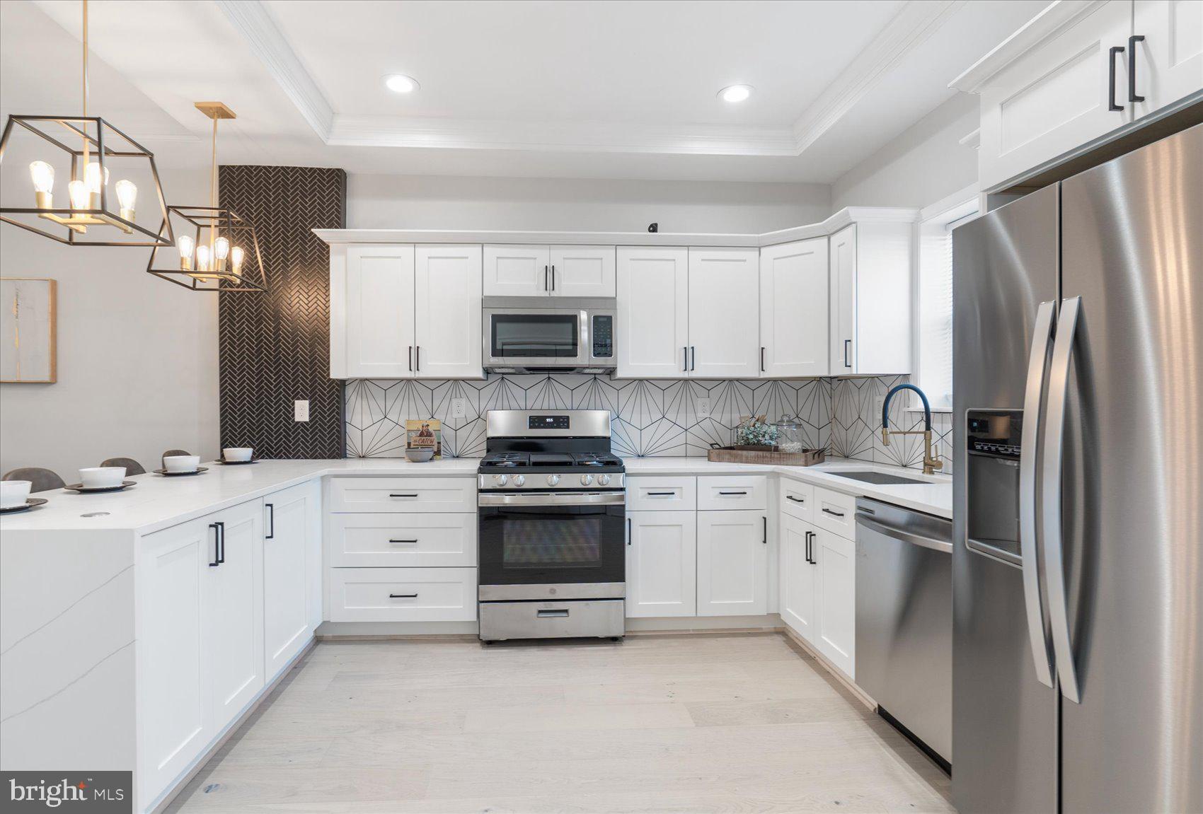 The photos displayed are of the model home! The delivery date on this home is February 2022.
This Magnificent Townhome is the perfect location to call home. Your new home boasts 5 bedrooms, 3.5 bathrooms, a finished basement, modern designer kitchen, with multiple LED fireplace on each level. As you enter the space, you are greeted by an open and continuous floorplan that is flooded with natural light and modern amenities. Your eyes are automatically drawn upward to the dramatic coffered ceiling with an industrial-sized ceiling fan and a gorgeous feature wall that is finished with a color-changing LED fireplace and open seating area. I know you will want to take a seat and spend time in the living room, but we must move forward into this amazing kitchen. This beautifully constructed eat-in kitchen features quartz countertops (with the waterfall design), stainless steel appliances, tray ceilings, a sleek backsplash, and a USB charging port for your convenience. You will want to celebrate the new year in this amazing space. Right off the kitchen is your private deck that is perfect for your morning coffee and overlooks your private off-street parking. This home has a luxury design that fits your budget. As you transition upstairs you will observe an elevated master suite with a massive walk-in closet and tasteful master bathroom. Outside of the master suite there are an additional two bedrooms and a bathroom on that level for your family’s convenience, but that is not the end. The basement is the perfect extension to your incredible home. Not only are there an additional bedroom and office, but a second family room that can be used as a flex space with a wet bar inclusion. Each home is equipped with a state-of-the-art security system with cameras for increased protection. Of course, I must sweeten the pot because this incredible home will save you money. This home qualifies for the High-Performance Tax Credit. In addition, this home is 6 of 12 on the block, and the quality is impeccable. As Phase 2 of this 3-phase development project hits the market they will sell quickly. Unfortunately, you missed your opportunity at phase 1 but don’t miss your chance now. If you want to get a better feel for the home a 3D Tour has been created just for you so tap on the movie camera icon. Every inch of this home has been meticulously constructed with you in mind, so DO NOT miss the opportunity by not moving fast enough.