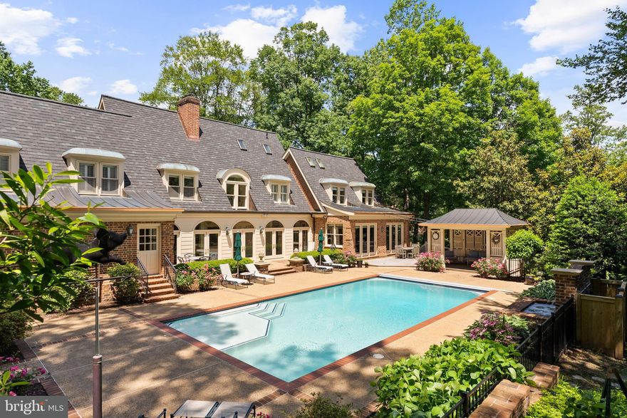 INCREDIBLE VALUE! Set on a serene 1.25-acre hilltop lot in the prestigious Langley Forest neighborhood, this exquisite 8,400 SF custom-built residence offers timeless design, exceptional privacy, and sweeping treetop vistas. Designed by renowned architect Robert Holland and crafted by builder Robert Clements in 1984, the home was further expanded by BOWA in 2001 and blends classic elegance with modern updates.

The main level boasts soaring 9'6" ceilings and a seamless flow between formal and informal living spaces. The open-concept kitchen and family room are perfect for entertaining, with direct access to the expansive rear deck, walkout patio, and a stunning swimming pool with gazebo—your private outdoor retreat! The mudroom features a full bath with easy access to the pool as well as a wet bar and second laundry room.

Upstairs, the home features four spacious bedrooms, including a luxurious primary suite with a fully renovated spa-like bath, complete with dual vanities and a walk-in shower, as well as two dressing rooms. Two of the secondary bedrooms offer unique lofted spaces, ideal for play, study, or creative use.

The lower level is designed for relaxation and recreation, featuring a large recreation room, exercise room, and full bath. A separate apartment suite above the 2-car garage provides flexible space for guests or a home office.

Additional highlights include a new roof, complete exterior repainting in 2024, and beautifully landscaped grounds. Zoned for Churchill ES, Cooper MS, and Langley HS.