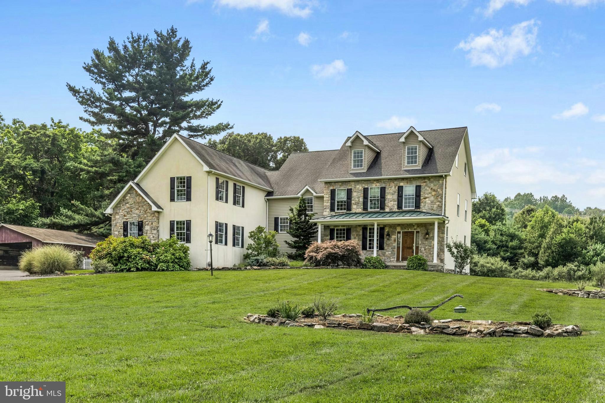 SUNRISE KNOLL An exceptional blend of modern day amenities and a bygone era, Sunrise Knoll is a reimagined farmhouse nestled on 6.27 acres in a convenient Saucon Valley location. A beautifully cared for custom built home with traditional farm outbuildings, including an Historic Pennsylvania bank barn, comprise the serene setting.
Gracious and open, the living areas are filled with natural light, high ceilings, front and back stairs, and picturesque views of the quiet surroundings. At the heart of the home is a stunning gourmet kitchen with cherry cabinetry, two islands, stainless appliances and breakfast area. The vaulted great room boasts a soaring stone fireplace and plentiful windows overlooking the picturesque land. An expansive dining room and living room shine with gleaming wood floors and a deep-silled window, perfect for formal and casual get-togethers.
Luxuriously outfitted with dual walk in closets, a jetted tub, and resort quality shower, the vaulted primary suite is a haven at day’s end. Three additional bedrooms.... one a bedroom suite.... a hall bath, and a second laundry room complete the second floor. Perfect for teens and guests, a third level bedroom suite has a vaulted ceiling, full bath, and a bird’s eye view of majestic sunrises. Hobbyists and gardeners will appreciate the expansive grounds with an original corn crib and 5-bay garage.
The distinctly rural feel is refreshing and peaceful, yet everyday essentials are close at hand. The perfect place to relax, or bring your horse, or simply take fabulous photos of sunsets or Holiday magic!