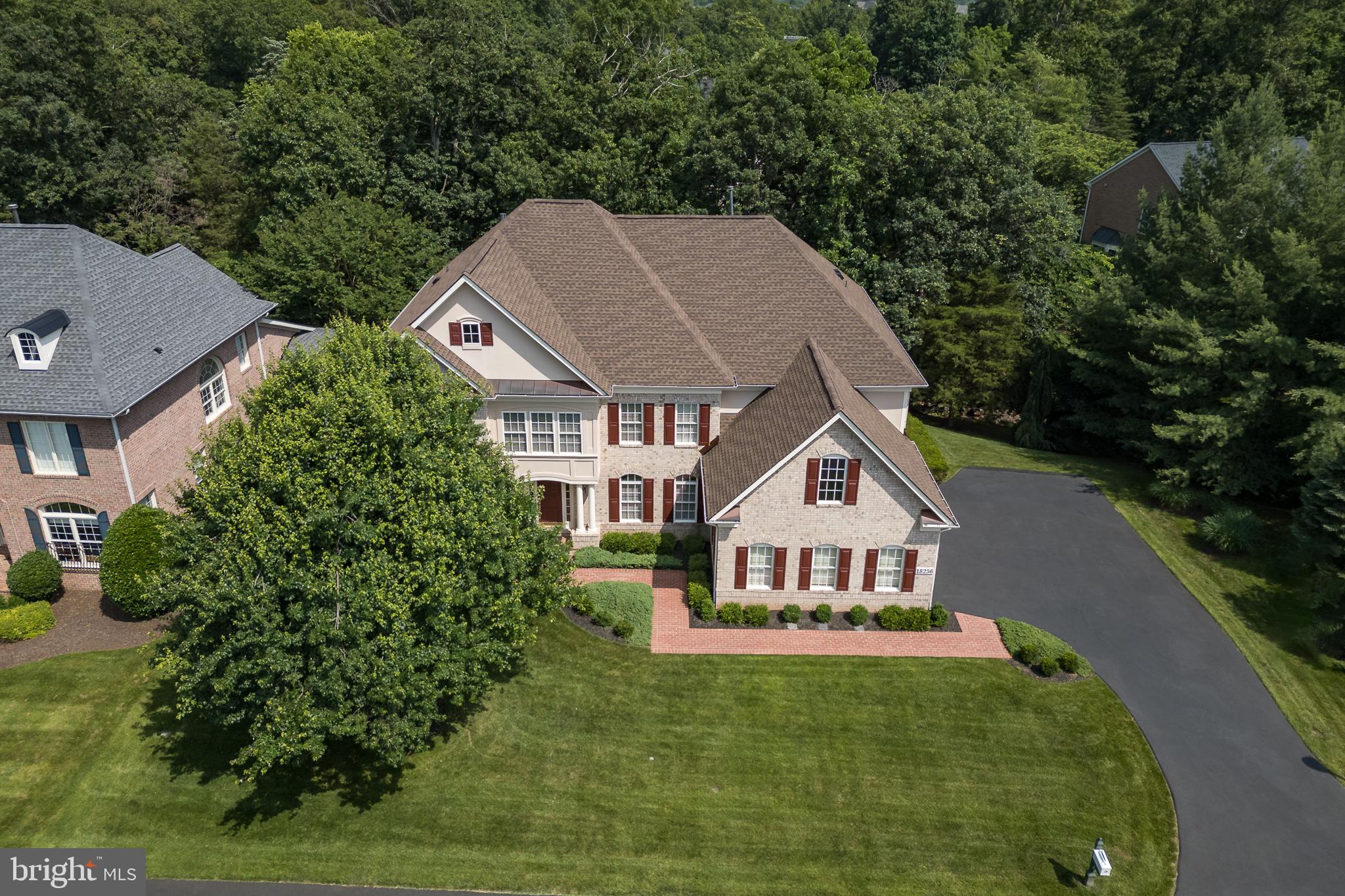 **Price Improvement**Introducing a remarkable custom-built home by Mitchell and Best, a custom builder whose motto is “What Vision Can We Bring To Life.” For the first time being offered, this stately, four-sided brick residence is rich with architectural details and accents, offering an impressive first impression. The property boasts a covered entrance and practical upgrades, including a newer extended driveway, newer garage doors, and a pristine garage featuring rubber flooring. Essential updates ensure peace of mind, such as Roof (2020) HVAC's (2019). A decorative covered brick patio, complete with an under-deck drainage system, deck stairs, and privacy lattice, provides exceptional outdoor enjoyment. Enjoy privacy on three sides of the property, with views of the golf course from the front, a natural tree buffer on one side, and mature trees and babbling brook views to the rear. Step inside to discover a beautifully appointed interior. The main level welcomes you with a grand foyer entrance and features such as upgraded trim, wainscoting and hardwood flooring throughout. The family room is enhanced by custom trim details and decorative columns. The formal living room offers flexibility as an optional piano room or untouched office. A versatile office, which can also serve as an optional bedroom, provides access to the deck and custom bookshelves. The inviting family room showcases marble flooring, a stone fireplace, a raised ceiling, decorative columns, recessed lighting, and a curved window wall with transom windows, creating a bright and airy space. The kitchen is a chef’s dream, complete with a butler’s pantry and an eat-in area. It features trim, tall mocha cabinets, recessed lighting, a cooktop with downdraft, a double oven, a SS refrigerator, a custom backsplash, a large island perfect for food preparation with ample space for four stools, a vegetable sink, a window over the sink, a large pantry, and a convenient desk area with a mail holder. Ascending to the upper level, you’ll find the luxurious primary suite, featuring a raised ceiling, cherry hardwood flooring, trim, a double-sided fireplace, and a sitting room that can be converted into an additional bedroom. A wet bar with a sink, beverage refrigerator, backsplash, and tile flooring adds a touch of indulgence. The opulent primary bathroom offers dual water closets, dual showers, garden tub, oversized tile flooring, granite countertops, and cherry cabinets. The dressing area includes full-length mirrors and a window bench, and two walk-in closets. Additionally, there is an en suite bedroom with a walk-in closet and private bath, as well as Jack and Jill bedrooms sharing a bath with one of the bedrooms offering the potential for an amazing office space with a custom window overlooking the grand foyer. The lower level provides fantastic additional living space. A custom bar with upgraded tile, a beverage refrigerator, granite countertops, a sink, a dishwasher, tile flooring, and glass cabinets is perfect for entertaining. The enormous lower-level family room offers distinct billiards and movie areas, enhanced by a double-sided fireplace. An extended sitting area provides additional comfort. Two generously sized bedrooms are also located on this level, along with a walk-out to a private all-brick covered patio. This amazing community offers resort amenities that include: over 7 miles of walking paths, a private park, kayaks, access to dining overlooking the Potomac River, multiple tennis/pickleball courts, swimming pools, exercise facility, secure community access and the option to become a member of River Creek Golf Club. Just outside of the community you will experience convenient access to a wide variety of shopping, entertaining options to include: One Loudoun, Town of Leesburg Wegmans, Whole Foods, Loudoun County Metro Stations, local restaurants, wineries, breweries, farm markets, bike trails, and so much more - Welcome to a Lifetime of Saturdays!