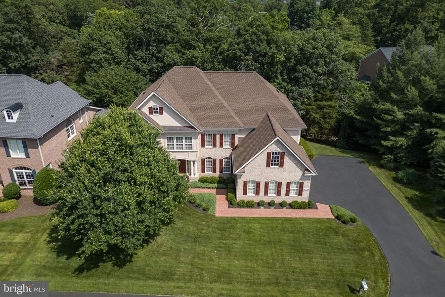 **MASSIVE Price Improvement** Remarkable custom-built home by Mitchell and Best, a custom builder whose motto is “What Vision Can We Bring To Life.” For the first time being offered, this stately, four-sided brick residence is rich with architectural details and accents, offering an impressive first impression. The property boasts a covered entrance and practical upgrades, including a newer extended driveway, newer garage doors, and a pristine garage featuring rubber flooring. Essential updates ensure peace of mind, such as Roof (2020) HVAC's (2019). A decorative covered brick patio, complete with an under-deck drainage system, deck stairs, and privacy lattice, provides exceptional outdoor enjoyment. Enjoy privacy on three sides of the property, with views of the golf course from the front, a natural tree buffer on one side, and mature trees and babbling brook views to the rear. Step inside to discover a beautifully appointed interior. The main level welcomes you with a grand foyer entrance and features such as upgraded trim, wainscoting and hardwood flooring throughout. The family room is enhanced by custom trim details and decorative columns. The formal living room offers flexibility as an optional piano room or untouched office. A versatile office, which can also serve as an optional bedroom, provides access to the deck and custom bookshelves. The inviting family room showcases marble flooring, a stone fireplace, a raised ceiling, decorative columns, recessed lighting, and a curved window wall with transom windows, creating a bright and airy space. The kitchen is a chef’s dream, complete with a butler’s pantry and an eat-in area. It features trim, tall mocha cabinets, recessed lighting, a cooktop with downdraft, a double oven, a SS refrigerator, a custom backsplash, a large island perfect for food preparation with ample space for four stools, a vegetable sink, a window over the sink, a large pantry, and a convenient desk area with a mail holder. Ascending to the upper level, you’ll find the luxurious primary suite, featuring a raised ceiling, cherry hardwood flooring, trim, a double-sided fireplace, and a sitting room that can be converted into an additional bedroom. A wet bar with a sink, beverage refrigerator, backsplash, and tile flooring adds a touch of indulgence. The opulent primary bathroom offers dual water closets, dual showers, garden tub, oversized tile flooring, granite countertops, and cherry cabinets. The dressing area includes full-length mirrors and a window bench, and two walk-in closets. Additionally, there is an en suite bedroom with a walk-in closet and private bath, as well as Jack and Jill bedrooms sharing a bath with one of the bedrooms offering the potential for an amazing office space with a custom window overlooking the grand foyer. The lower level provides fantastic additional living space. A custom bar with upgraded tile, a beverage refrigerator, granite countertops, a sink, a dishwasher, tile flooring, and glass cabinets is perfect for entertaining. The enormous lower-level family room offers distinct billiards and movie areas, enhanced by a double-sided fireplace. An extended sitting area provides additional comfort. Two generously sized bedrooms are also located on this level, along with a walk-out to a private all-brick covered patio. This amazing community offers resort amenities that include: over 7 miles of walking paths, a private park, kayaks, access to dining overlooking the Potomac River, multiple tennis/pickleball courts, swimming pools, exercise facility, secure community access and the option to become a member of River Creek Golf Club. Just outside of the community you will experience convenient access to a wide variety of shopping, entertaining options to include: One Loudoun, Town of Leesburg Wegmans, Whole Foods, Loudoun County Metro Stations, local restaurants, wineries, breweries, farm markets, bike trails, and so much more - Welcome to  a Lifetime of Saturdays!