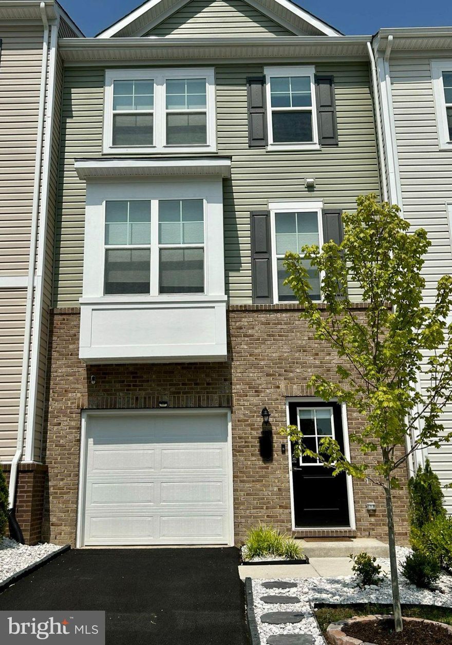 Built in 2022, this beautifully maintained 3-level townhome offers a spacious, well-designed floor plan with 4 bedrooms, 3.5 baths, a 1-car garage, and driveway parking, perfectly combining comfort, style, and convenience. Backing to wooded views, this home delivers modern living in a peaceful setting.

The entry-level features a welcoming foyer with direct garage access and a versatile fourth bedroom or flex space, ideal for a guest suite, gym, home office, or recreation area.

The main level showcases a bright, open-concept layout with large windows, filling the space with natural light. The gourmet kitchen is the centerpiece, featuring a large island with seating and sink, gas range, large pantry, and abundant recessed lighting. The dining area flows seamlessly into the spacious living room. Step outside to a covered deck overlooking the fenced backyard and trees, creating the ideal indoor-outdoor lifestyle. An easy access half bath completes this level.

Upstairs, the owner’s suite offers a private retreat with two oversized walk-in closets and a spa-inspired bath featuring dual vanities and oversized walk-in shower. Two additional bedrooms, a full hall bath, and a laundry area complete the upper level.

Hardwood flooring throughout. Freshly painted and professionally cleaned, making this home truly move-in ready for you.

Ideally located near Quantico Marine Corps Base, Fort Belvoir, major commuter routes, shopping, and dining, this home offers both convenient living and ease of ownership.

Light-filled, thoughtfully designed, and ready for you. Schedule your private tour today!