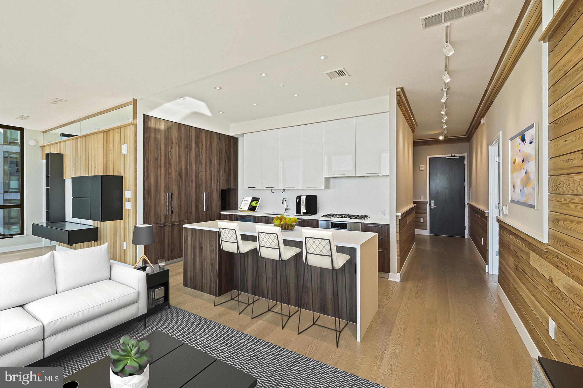 The Seller is offering below market financing at 4.50% fixed rate to qualified purchasers. (See agent for details.) Architect’s personal residence designed with extensive high-quality upgrades, including custom cabinetry and millwork. This 1,617-square-foot, 2-bedroom, 2-bath condo with a den is a stunning masterpiece of Mid-Century-inspired design, custom-appointed by its renowned architect-owner, John G. Colby, AIAE. Floor-to-ceiling windows flood the spaces with natural light, offering breathtaking panoramic views and making daily sunsets a dream come true. The gourmet kitchen, designed by award-winning Cecconi Simone, features Italian cabinetry, composite stone countertops, Bosch appliances, and a sleek island with a waterfall edge—perfect for intimate evenings or entertaining guests in style.
The primary suite is a serene retreat, complete with a custom LED-lit headboard, recessed lighting, and two spacious walk-in closets. The luxurious en-suite bath boasts an Italian-made double vanity and a frameless glass walk-in shower, creating a spa-like oasis. The generously sized secondary bedroom is paired with a conveniently located full bath adjacent in the hall. A private den is outfitted with custom cabinetry and an L-shaped quartz desk. The space provides a highly functional and stylish workspace or an additional relaxation area. Two premium parking spaces and a large storage unit further enhance the convenience of this exceptional property.
The Verse Condominium offers an unparalleled resort-style living experience with 24/7 concierge services. Residents and guests are welcomed into a sophisticated lobby and enjoy access to a grand entertainment lounge with a gourmet kitchen, ideal for hosting gatherings. The high-performance fitness center caters to health-minded enthusiasts, while the expansive half-acre sky park on the 9th floor includes a kitchen, bar, gas grills, outdoor dining areas, fire pits, and TV screens for socializing and unwinding. The 14th-floor rooftop pool area is the perfect urban retreat with chaise lounges and panoramic park views. Additional amenities include secure bicycle storage with a repair station, a pet spa with grooming facilities, a guest suite with hotel-inspired accommodations, and a secure resident-only garage.
Nestled in The Boro, Tysons’ premier lifestyle destination, The Verse is just steps away from Whole Foods, Starbucks, the ShowPlace ICON Theatre, and a diverse selection of restaurants and shops. The Greensboro Metro Station, located only 0.3 miles away, ensures seamless connectivity to Washington, D.C., and beyond. The monthly condo fee covers all utilities except electricity and cable/internet, providing a hassle-free living experience in a meticulously maintained community.
Schedule a viewing today to discover the unparalleled luxury and convenience of life at The Verse!