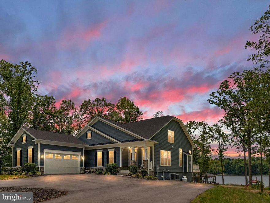 Experience the ultimate in luxury waterfront living at beautiful Lake Anna with a rare opportunity to own a stunning retreat that offers not only an incredible lifestyle, but also exceptional investment potential. Projected 2026 rental revenue is estimated between $175,000–$225,000, making this extraordinary property a luxury waterfront home that can almost pay for itself. Nestled in the highly sought-after Elk Creek Landing subdivision on the private side of the lake, this resort-style oasis delivers breathtaking sunsets, huge open water views, 250 feet of pristine shoreline, and the peaceful privacy that makes Lake Anna so special.

A paved circular driveway welcomes you to this beautifully appointed waterfront retreat offering over 5,500 square feet of thoughtfully designed living space with 5 spacious bedrooms, 4 full bathrooms, and a loft perfect for kids or additional guest space. Designed for entertaining and unforgettable lake memories, the open-concept floor plan seamlessly blends luxury and comfort with upscale finishes throughout, including a dramatic floor-to-ceiling stone fireplace, expansive wet bar with oversized island, upgraded countertops, massive kitchen center island, double wall ovens, Luxury Vinyl Plank flooring, recessed lighting, Hardiplank siding, extensive hardscaping, and more. The home also features a fully equipped exercise room and an incredible media room perfect for movie nights, game days, and rainy days at the lake. High-speed fiber internet is available, allowing you to work remotely while enjoying lakefront paradise.

Step outside and immerse yourself in true waterfront resort living. Enjoy the beautiful level rear yard that gently leads down to the water’s edge, creating the perfect setting for outdoor games, gatherings, and effortless access to the lake. Wander past the fire pit down to your private waterfront playground featuring a massive boathouse with two slips, electric lifts, storage room, expansive dock bar with two roll-up serving windows perfect for unforgettable dock parties, covered lounging area, sun deck, swimming area, and your very own private sandy beach — the perfect spot to relax, swim, launch your float, or spend endless summer days on the water. Whether hosting family and friends or enjoying a quiet evening watching the sunset over the lake, every detail of this property was designed to create an unforgettable experience.

Offered furnished, this exceptional retreat allows you to move in and immediately begin enjoying the Lake Anna lifestyle or continue operating it as a highly desirable luxury rental investment. Conveniently located approximately 45 minutes from Richmond and about 90 minutes from Washington, you'll enjoy easy access to local waterfront dining, shopping, groceries, entertainment, and everyday conveniences while still enjoying the privacy and tranquility of lakefront living. Schedule your private tour today and discover what luxury waterfront living at Lake Anna is truly all about.