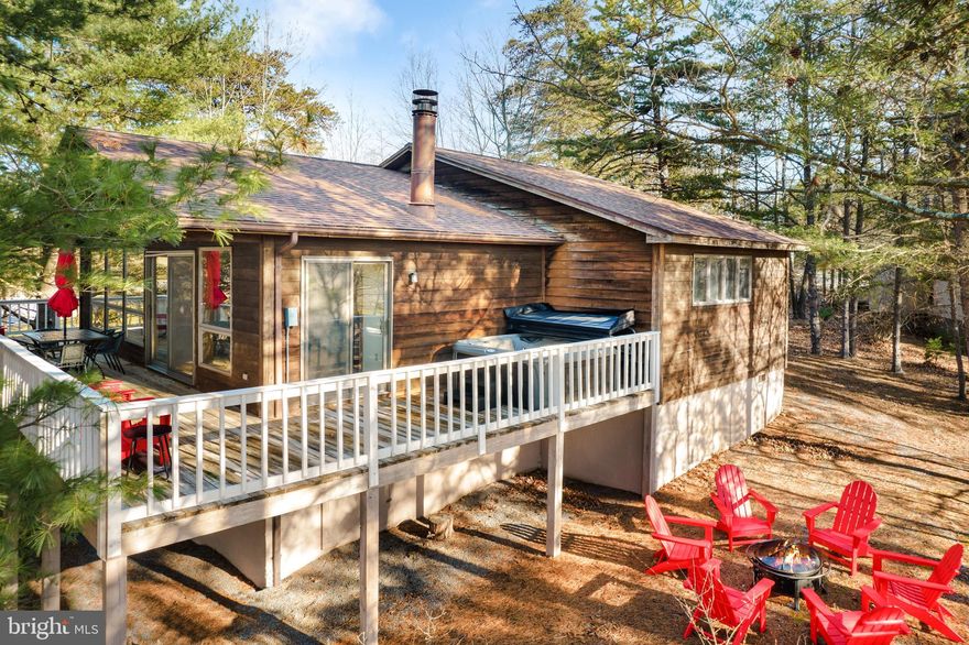 Spacious 2-bedroom, 2-bath newly-renovated chalet cabin in The Woods Resort! The seller has spent over $41,000 upgrading & furnishing the property.  Stunning floor-to-ceiling windows and high ceilings, tons of natural light, & inviting living room with a wood-burning fireplace.  Central AC and strong WiFi.  Outside you’ll find a large wraparound deck and a brand new hot tub.  The cabin includes Class B membership at The Woods, and is located just steps from the golf course and 1 mile from the club house/pool/gym.  As a vacation rental it generates $51k per year in rental income ($120k over the past 30 months!), and can come with an existing property manager and cleaner. Hot tub and furniture optional, available for purchase.  See seller docs for a summary of rental history and financials.  $1,000 buyer credit if you continue using the same property manager.  Perfect vacation home or investment property!