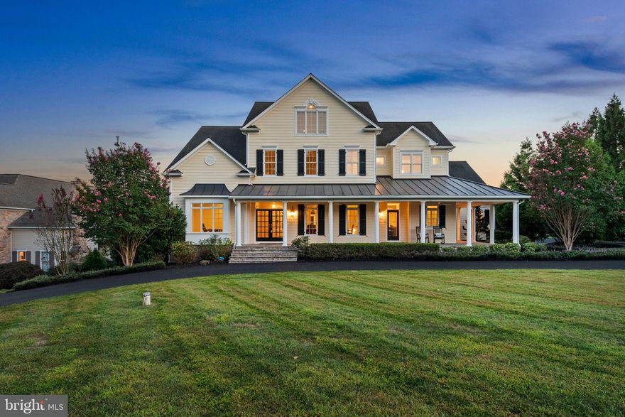 An expansive circular driveway framed by lush landscaping leads to a 2 1/2-car side garage and this stately colonial residence, featuring charming pale yellow Hardiplank siding and stone with classic black shutters and elegant double French front doors. The home is graced by a wrap-around stone front porch with multiple access points, ideal for relaxing mornings while enjoying the serene views.

The interior is meticulously designed with pristine attention to detail, showcasing grand arched doorways, elegant columns, recessed lighting, and intricate crown moldings. Hardwood floors flow through expansive open living spaces, all enhanced by custom finishes and luxurious touches, creating an atmosphere of timeless sophistication throughout the home. 

Proceed into the open-concept kitchen and adjoining keeping room, highlighted by a cozy gas fireplace. The sun-drenched family room boasts another gas fireplace, framed by floor-to-ceiling stone, with a stylish alcove for a large television and access to the serene back porch. The main level also includes a versatile bonus room with custom built-ins, ideal for an office or study area, a convenient mudroom, a meticulously designed laundry closet, and two elegantly appointed powder rooms. 

The updated eat-in kitchen features top-of-the-line GE Monogram® stainless steel appliances and gleaming hardwood floors. An expansive island with seating for at least three serves as a focal point, complemented by a white subway tile backsplash, elegant granite countertops, ample 42” cabinets, including some with glass fronts for added charm, an integrated refrigerator, dual pantries, and a stunning custom stone range hood cover.

The owner’s suite, conveniently located on the main level, offers a luxurious retreat with its own gas fireplace and plush carpeting. Enjoy private access to the screened porch, perfect for relaxing in solitude. The suite features an expansive walk-in closet with custom built-ins and an adjoining spa-like bathroom. This exquisite bathroom includes an air-jetted tub, a walk-in Roman® shower with a sleek, doorless design, a separate water closet, and dual vanities for added convenience.

Upstairs is a versatile loft space with built-in bookcases, a second laundry room, and three generously sized carpeted bedrooms each with a walk-in closet and attached full bathroom. Two of these bedrooms are connected by a whimsical secret pass-through. The uppermost level houses an oversized fourth bedroom with an attached full bathroom for extra privacy.

The lower level is an entertainer’s dream, featuring a sprawling recreation room that seamlessly opens to a covered patio with a unique patterned ceiling. Enjoy movie nights in the thrilling tiered home theater or transform the bonus room into your personal home gym. This level also includes a convenient third laundry room, a spacious sixth bedroom, and two full bathrooms, making it ideal for hosting unforgettable gatherings or creating your own entertainment hub.

This breathtaking backyard oasis is the ultimate luxury escape, crafted to leave a lasting impression. Dive into the saltwater pool with a stunning waterfall feature, diving board, and a thrilling, oversized slide, all framed by lush, manicured landscaping. Unwind in the hot tub or gather around the built-in fire pit for cozy evenings. The expansive tiered patio and enclosed screened composite porch provide perfect settings for alfresco dining and seamless indoor-outdoor entertaining. With an open yard backing to serene woods, this fully fenced retreat offers both privacy and picturesque views, creating a truly unparalleled outdoor haven.

Fox Meadow is a picturesque community with rolling countryside and beautifully landscaped lots. Residents enjoy rural tranquility while being close to popular destinations like Turf Valley Towne Square, Patapsco State Park, cozy local eateries, upscale restaurants, and commuter routes I-70, Route 32, and Route 29.
