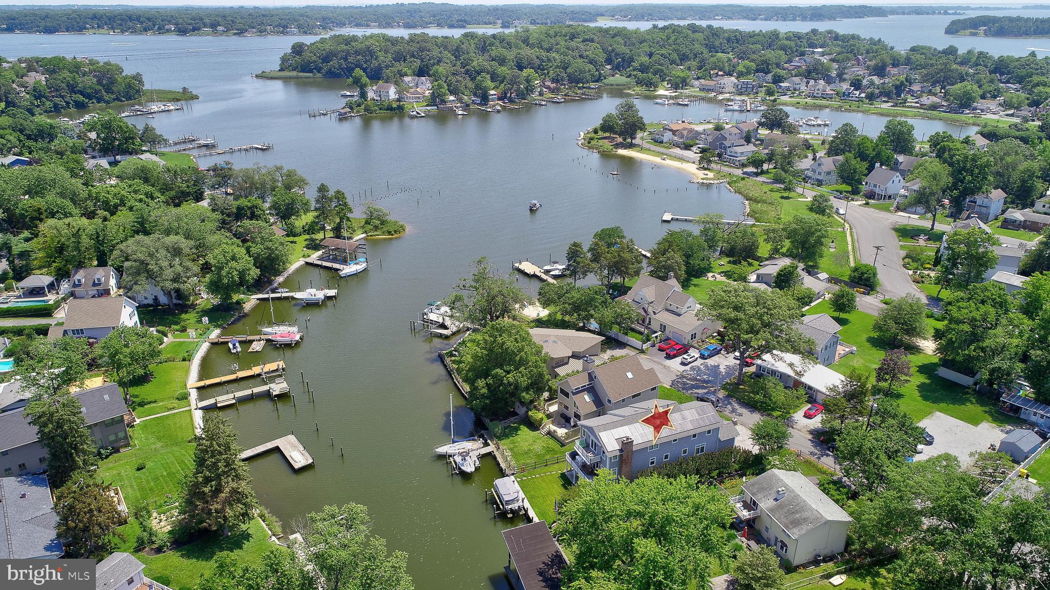 Welcome to Your Waterfront Retreat! Nestled along the tranquil shores of Almshouse Creek, this immaculate 4-bedroom home features 3 full and 2 half baths and offers a perfect blend of luxury and lifestyle. Ideal for boating enthusiasts, entertainers, or those seeking serenity, this property is a rare find. Enjoy seamless waterfront living with a private, bulkheaded dock and a 12,500 lb. boat lift—your personal launchpad to the tranquil beauty of the South River. Hop aboard and within minutes, you're gliding into a world of scenic cruises, weekend adventures, and golden-hour sunsets. Whether you're chasing the horizon or anchoring for a quiet moment near Thomas Point Shoal Lighthouse, this location offers more than access—it offers a lifestyle. Enjoy serene water views while relaxing in the outside hot tub. This level also boasts an oversized heated 3-car garage, a well-organized utility room, and an inviting recreation room complete with a wet bar and direct walk-out access to the private dock. The upper level's open-concept design is equally impressive. The chef’s kitchen is equipped with upgraded counters, a Sub-Zero refrigerator, double wall oven, warming drawer, two sinks, and a spacious pantry, making it a culinary enthusiast's dream. The expansive living and dining areas are centered around a cozy ‘Quadra Fire’ wood insert, a walk out to the waterfront balcony with retractable awning, laundry room, half bath, a primary suite, and an additional full bath. The top floor reveals a second luxurious primary suite featuring a vaulted ceiling, a large walk-in closet, a second private balcony with water views and retractable awning, and a spa-inspired bathroom with a European walk-in shower, a soaking tub, and double vanities. There are 2 additional bedrooms, another full bath, and a second laundry room. Additional notable features include Ipe wood decks, electric blinds, Brazilian wood floors, an irrigation system, raised garden beds, owned solar panels, and a reverse osmosis system. Ample storage is available, and every detail has been meticulously maintained by the current owners. The community of Pine Whiff Beach has a voluntary HOA fee of $100.00 per year. Located on a quiet dead-end street with a community beach on one end and Parks and Recreation Land on the other end. Located just 20 minutes from Annapolis, with convenient access to Washington D.C., Maryland's Eastern Shore, and Baltimore. This location offers an easy commute to BWI Airport, Northrop Grumman, and Fort Meade/NSA. Come experience the unparalleled beauty, comfort, and ease of life at 1539 Pine Whiff Ave.