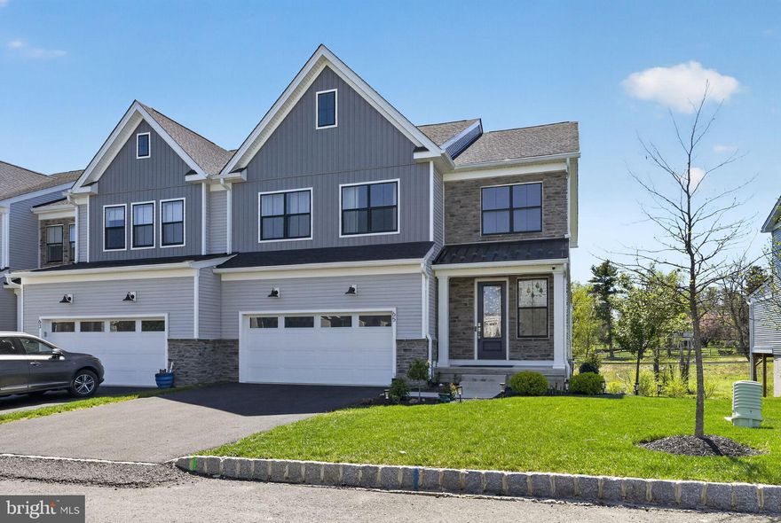 Stunning End-Unit Luxury Carriage Home in Doylestown Walk – Move-In Ready!

Experience the perfect blend of elegance, comfort, and modern design in this almost-new end-unit carriage home located in the highly sought-after Doylestown Walk community. Built by Toll Brothers, this exceptional Derby Elite floor plan offers over 4,000 square feet of beautifully finished living space, including a fully finished walk-out basement.

Step into a dramatic two-story foyer featuring upgraded 8” wide luxury plank flooring that flows throughout the main level. The open-concept layout is filled with natural light and designed for both everyday living and entertaining. The expansive family room seamlessly connects to a chef’s dream kitchen, complete with upgraded soft-close cabinetry, mosaic tile backsplash, and an impressive 12’ x 4’ quartz island with seating and designer pendant lighting.

The gourmet kitchen is equipped with high-end appliances, including a 36” six-burner JennAir gas range with hood, double ovens, farmhouse undermount sink, and a French-door Samsung refrigerator with customizable panels. A spacious dining area overlooks the backyard, while a large pantry and functional mudroom-style entry through the garage for added everyday convenience. The main level also includes a powder room and access to the oversized 2-car garage.

Upstairs, a wide oak staircase with craftsman-style railing leads to a versatile loft—perfect for a home office, media room, or play space. The luxurious primary suite is a true retreat, featuring abundant natural light, recessed lighting, ceiling fan pre-wire, and a spa-inspired en-suite bath with dual vanities, elegant tile flooring, a walk-in shower with seating, and a generous walk-in closet with attic access.

Two additional spacious bedrooms offer ample closet space and natural light, complemented by a full hall bath. A convenient second-floor laundry room includes a washer, dryer, and utility sink. Plush upgraded carpeting and padding extend throughout the upper level.

The fully finished walk-out basement  provides exceptional additional living space—ideal for entertaining, a home theater, or gym—and includes a 3-piece rough-in for a future bathroom, along with abundant storage.

Additional highlights include 9-foot ceilings on all levels, central water filtration system, and outdoor access to the backyard and side yard—perfect for gardening or relaxing.

Located just minutes from downtown Doylestown, this home offers the perfect balance of peaceful community living with easy access to shopping, dining, and major commuter routes.