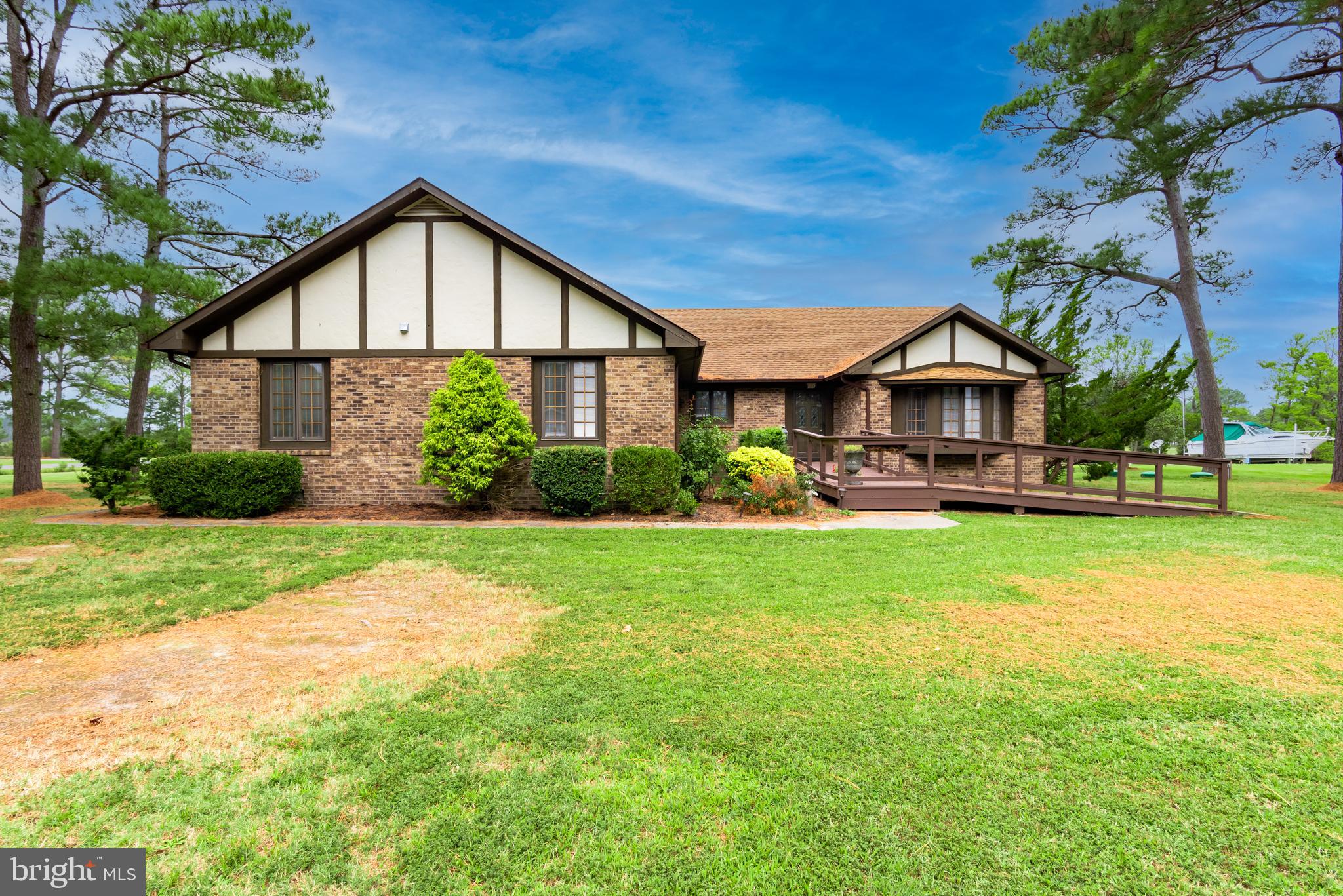 Attractive brick home on large lot (.89 ac) in waterfront community on corner lot. Bulkheaded with a dock, and four boat lift pilings, on wide canal that leads to Jones Creek. Open floor plan with large living room with fireplace and separate dining area. Enclosed sun room off of the living area leads to a deck for enjoying the birds and breezes. Master bedroom has bay window, large bathroom with dressing area, separate shower and tub. Hall bath has a walk in tub/shower, large mudroom/utility with separate pantry. Huge garage has a gardening/tool room with outside door, and a separate bathroom that needs some work. Hardwood flooring was installed in all living areas except where tiled in 2015. Heat pump was newly installed in October 2022, and septic 3150 gallon holding tank was installed in January 2022. Owner installed low flush toilets, water saving faucets, dishwasher and washing machine. Call agent for details. Interior photos by September 29.