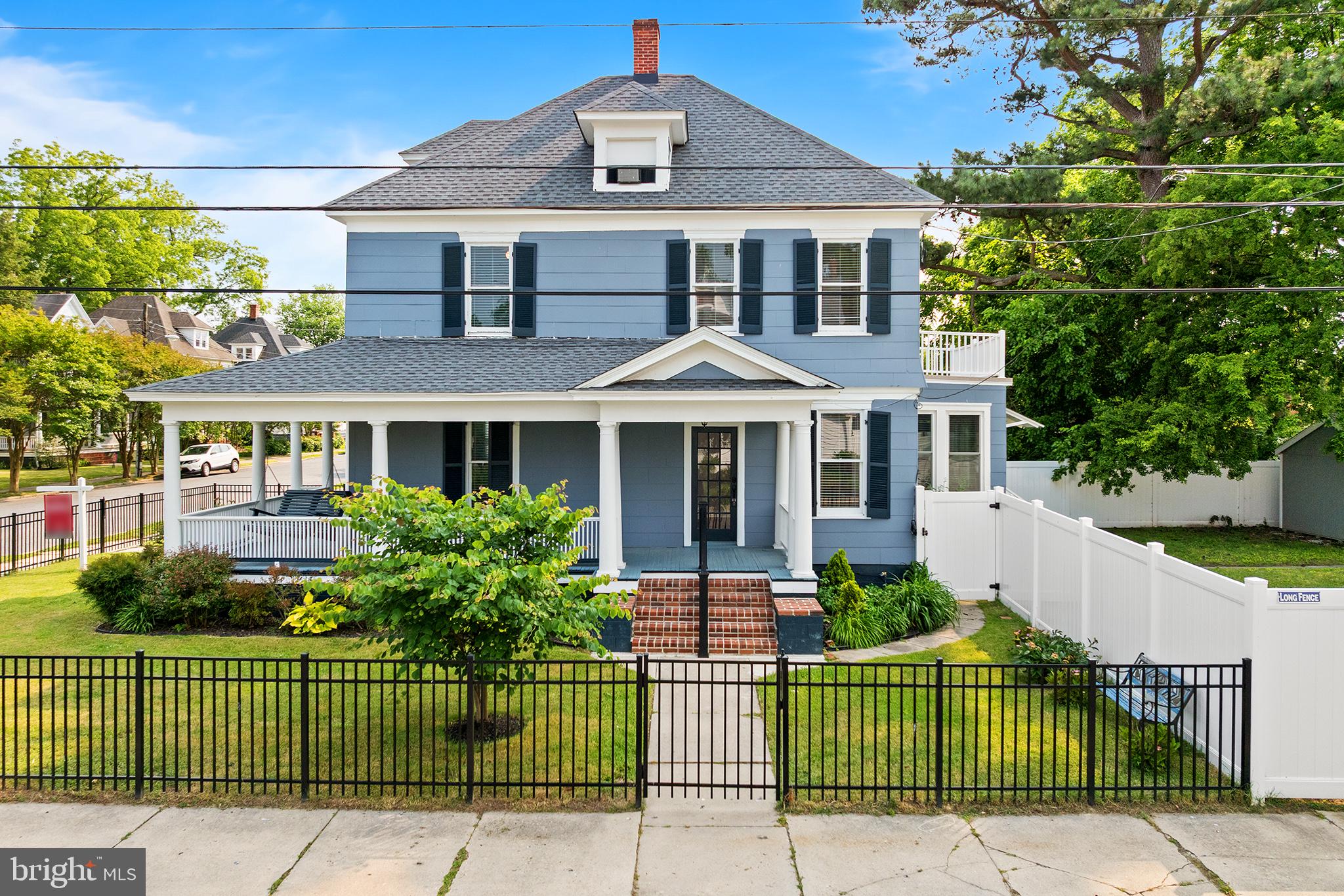 Steps from the water and located in Cambridge’s sought-after historic West End District, this timeless corner-lot home blends grand architectural charm with modern updates for truly inspired living. A welcoming wraparound porch sets the stage, leading into a bright and spacious interior featuring gleaming hardwood floors, soaring ceilings, recessed lighting, and abundant natural light throughout. The formal entry foyer opens to a warm living room with a gas fireplace and a classic dining room, flowing into a bright kitchen. The main level also offers a convenient powder room and laundry area. Upstairs, you’ll find a versatile open landing ideal for reading or work, a second laundry area, two generous bedrooms, and two full bathrooms—including a beautifully updated primary suite with dual vanities, a large standing shower, a spacious closet, and a private balcony overlooking the backyard. The third floor adds a third bedroom and a large storage area, with potential to convert into an additional bedroom or bath.  A detached art studio with a mini split system and electricity offers the perfect creative or remote work space and can be converted back into a garage if desired; an additional shed provides extra storage. The fully fenced yard is thoughtfully separated into two areas, perfect for pets and outdoor living. Recent updates include a new roof, HVAC, mini-splits, water heater, and fencing, all since 2023. This one-of-a-kind property is just blocks from the Choptank River, offering stunning views, boating, fishing, and waterfront dining. This is a rare opportunity to own a truly special piece of the Eastern Shore. Motivated seller - make an offer!