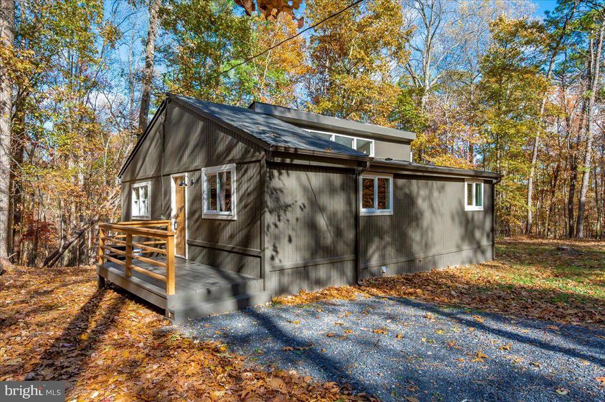 What hasn’t been done here? This jewel box on a .75-acre level lot with mature hardwoods has been taken down to the studs and completely reimagined by South County Ventures with licensed contractors at every step. From the new architectural roof and gutters to upgraded wiring, insulation, HVAC, and plumbing, the essentials are as fresh as the stylish finishes inside.

Step inside from the brand-new front deck and you’re immediately struck by the openness of the floor plan. To the right, a magnificent kitchen shines with all-new soft-close cabinetry, quartz countertops, stainless GE appliances, and a custom coffee bar. Beyond, the living and dining spaces flow seamlessly together, anchored by a sliding glass door that leads to the rescreened porch—a natural extension of the home’s gathering spaces.

Both bedrooms feature vaulted ceilings, creating an airy, spacious feel, plus large closets and new carpet for comfort. One bedroom even includes a washer/dryer hookup tucked into a closet for convenience.

The thoughtful updates continue outside, with extensive tree removal, fresh paint, and every detail dialed in. Nothing was overlooked—from the addition of new gutters to pumping and inspecting the septic (5/2025) to installing fresh insulation and a vapor barrier in the crawl space—every choice reflects the same commitment to lasting quality and comfort.

This is a move-in ready retreat in The Woods, blending modern comfort with the charm of a wooded setting.

Please note: This home does not currently include a Woods Club membership, but buyers may inquire about adding either a Class A or Class B membership (one-time initiation fee of $3,150 applies).
Home is professionally staged; furnishings and décor do not convey.
An itemized list of completed renovations is available upon request.
Seller is a licensed Real Estate Agent in Maryland and Pennsylvania