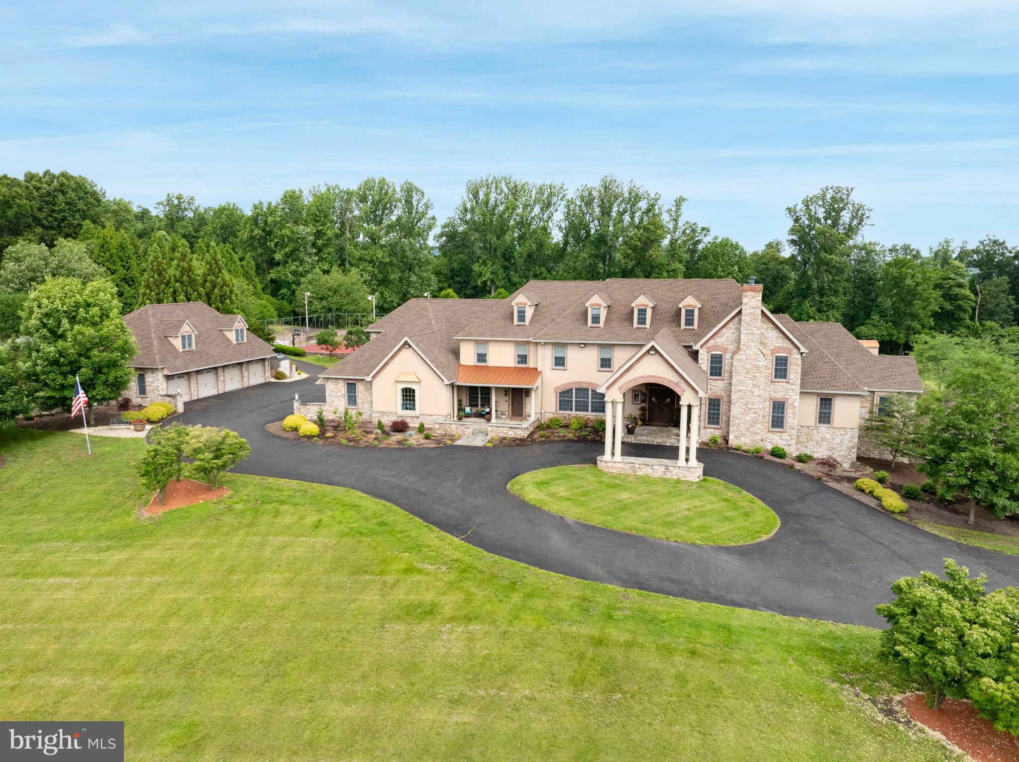 This exceptional property offers privacy, seclusion, and every imaginable amenity. Nestled on 9.3 acres, it welcomes you with a winding driveway leading to a grand two-story foyer. The elegant two-story library features a coffered ceiling, intricate dentil crown molding, a three-sided balcony, a propane fireplace, and a spiral staircase. A standout feature is the extraordinary three-story atrium indoor pool area, accessible from every level. Two walls of massive doors open to the outdoor living area, creating a lavish loggia with power screens. The ozone-purified pool boasts waterfalls, a curved water slide, and an adjoining hot tub, all surrounded by tropical decor, murals, ponds, built-in sound, balconies, and seating areas. A multi-tray ceiling with a mural and up-lighting enhances the ambiance. A changing room with a double shower and bath ensures convenience. Adjacent to the atrium is a mix of functional and entertaining spaces, including a sitting area with a propane fireplace, a game area, a craft/storage room, a powder room, and a full Jennaire kitchen and bar. Off the game room, there’s a full circuit gym, storage area, and stairs leading to a home theater, music room, and wine room. Two private in-law/guest suites each feature a private entrance, kitchen, living area, bedroom, stackable washer/dryer, and carport parking. The main kitchen is a chef’s dream, boasting a six-burner Viking stovetop with griddles, wall ovens, a warming drawer, an Advantium microwave, a large center island with a breakfast bar, two dishwashers, and a trash compactor. Additional highlights include a cabinet-front walk-in pantry, double Thermador stainless steel refrigerator/freezer, and a beverage center with a built-in coffee maker. The open floor plan flows into the family room with a vaulted ceiling and propane fireplace, while the great room features high ceilings and another propane fireplace. French doors in the kitchen, family, and great rooms open to the balcony overlooking the atrium pool. A butler’s kitchen leads to the formal dining room with a tray ceiling and up-lighting. The first floor also includes a playroom, a mudroom with cubbies, two powder rooms, a laundry room with commercial washers/dryers and a work island, and the master suite. The master retreat features a faux-finished tray ceiling with lighting, a beverage center, and private balcony access overlooking the pool and outdoor covered deck. The double-sided propane fireplace leads into the spa-like master bath with a jetted corner tub, walk-in shower with multiple jets and rain shower, heated towel rack, and two custom walk-in closets. The second and third floors include an office and five additional bedrooms. Unique features of this home include an elevator, laundry chute, whole-house generator, and attached four-car garage. The grounds are a masterpiece, offering breathtaking views, detached insulated multi-level garage parking for six vehicles, upper and lower patios, outdoor lighting, a full basketball/tennis court with lighting, multiple fire pits, two play areas with rubber flooring, a treehouse, drinking fountain, and a small animal barn with electric and water. The outdoor pavilion is the ultimate cookout space with covered seating, a built-in fridge, grill, and double cooktop burner. This property is also equipped with a full security system along with cameras surrounding the property, and don't forget the full house stereo and intercom system! Three additional adjacent parcels totaling 10.6 acres are also available for purchase. Seller is actively in the process of appealing their current tax assessment. This incomparable property astounds with every detail, schedule a private showing today!
