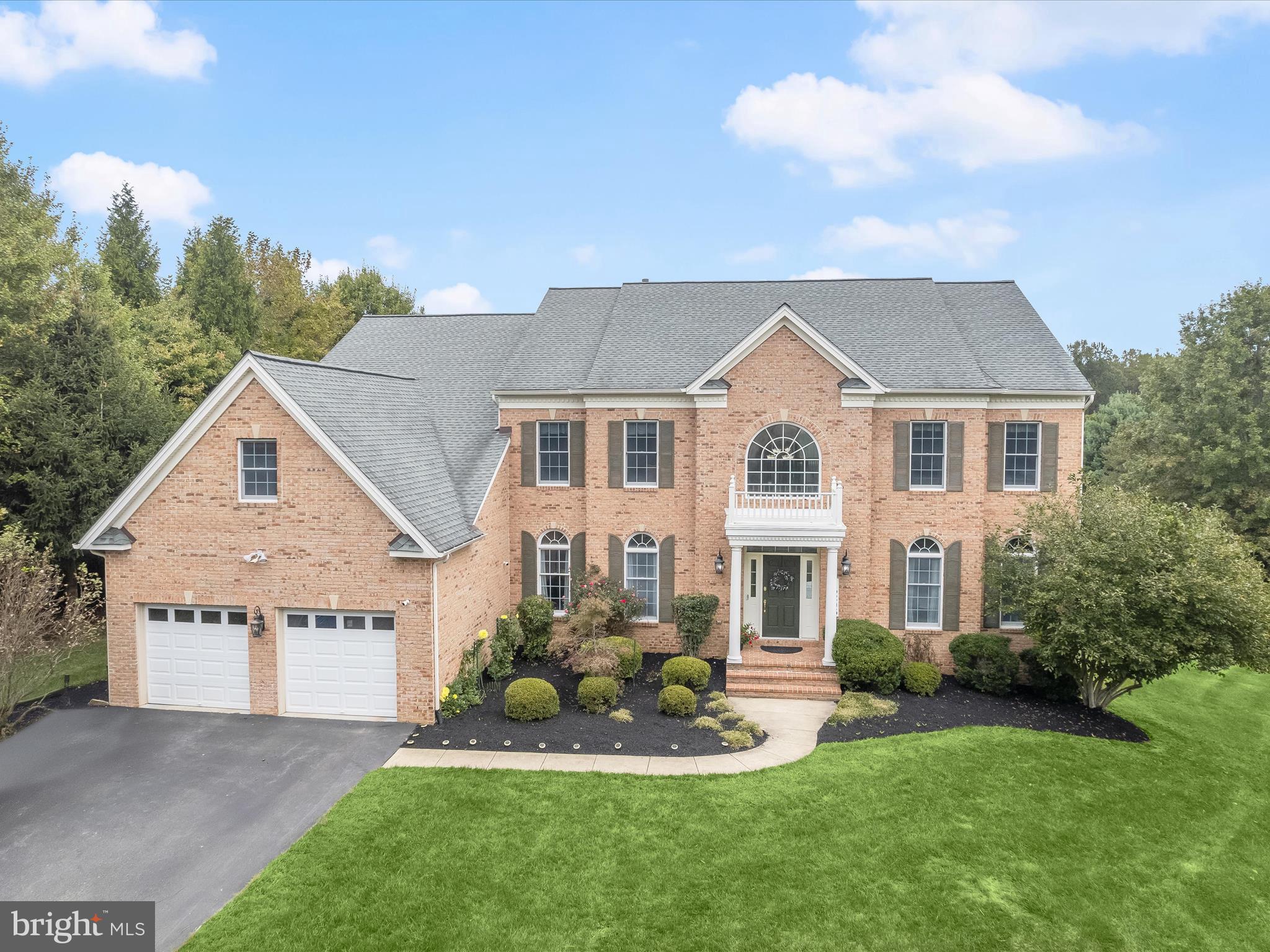Discover an unparalleled blend of elegance, comfort, and privacy in this stately Colonial on over 1 acre, nestled at the end of a tranquil cul-de-sac and backing to serene wooded views. With more than 8,000 square feet of finely crafted living space, this residence is designed for those who appreciate luxury living at its finest. A dramatic two-story foyer with a graceful staircase and architectural columns sets an impressive tone, flanked by formal living and dining rooms enhanced with rich accent moldings. Gleaming hardwood floors lead into the expansive gourmet kitchen, showcasing an oversized granite island, custom cherry cabinetry, premium stainless steel appliances, and seamless access to an expansive deck with canopy, the perfect vantage point for enjoying picturesque views. The sunlit two-story family room features soaring windows and a striking wood-burning fireplace with brick surround, creating a grand yet inviting gathering space. Additional main-level highlights include a spacious mudroom and laundry room with granite countertops, utility sink, cabinetry, extra refrigerator, and direct garage access, as well as a dedicated office and elegant powder room. Upstairs, retreat to the opulent primary suite complete with a private sitting room, spa-inspired bath with soaking tub, separate shower, dual vanities, and two expansive walk-in closets. Three additional bedrooms each offer en suite bathrooms, ensuring comfort and privacy for family or guests. The fully finished lower level is an entertainer’s dream, offering a recreation room, game room, and media room with built-in speakers and projector. Two versatile bonus rooms, a full bath, and a wide walk-up to the backyard complete this extraordinary space. Enjoy outdoor living on over 1 acre of lush, landscaped lot on the expansive deck and stone patio offering a scenic, tree-lined view . A two-car garage and an expansive driveway provide ample parking. Ideally located near premier dining, shopping, entertainment, and major commuter routes, this exceptional home perfectly balances luxurious living with everyday convenience.