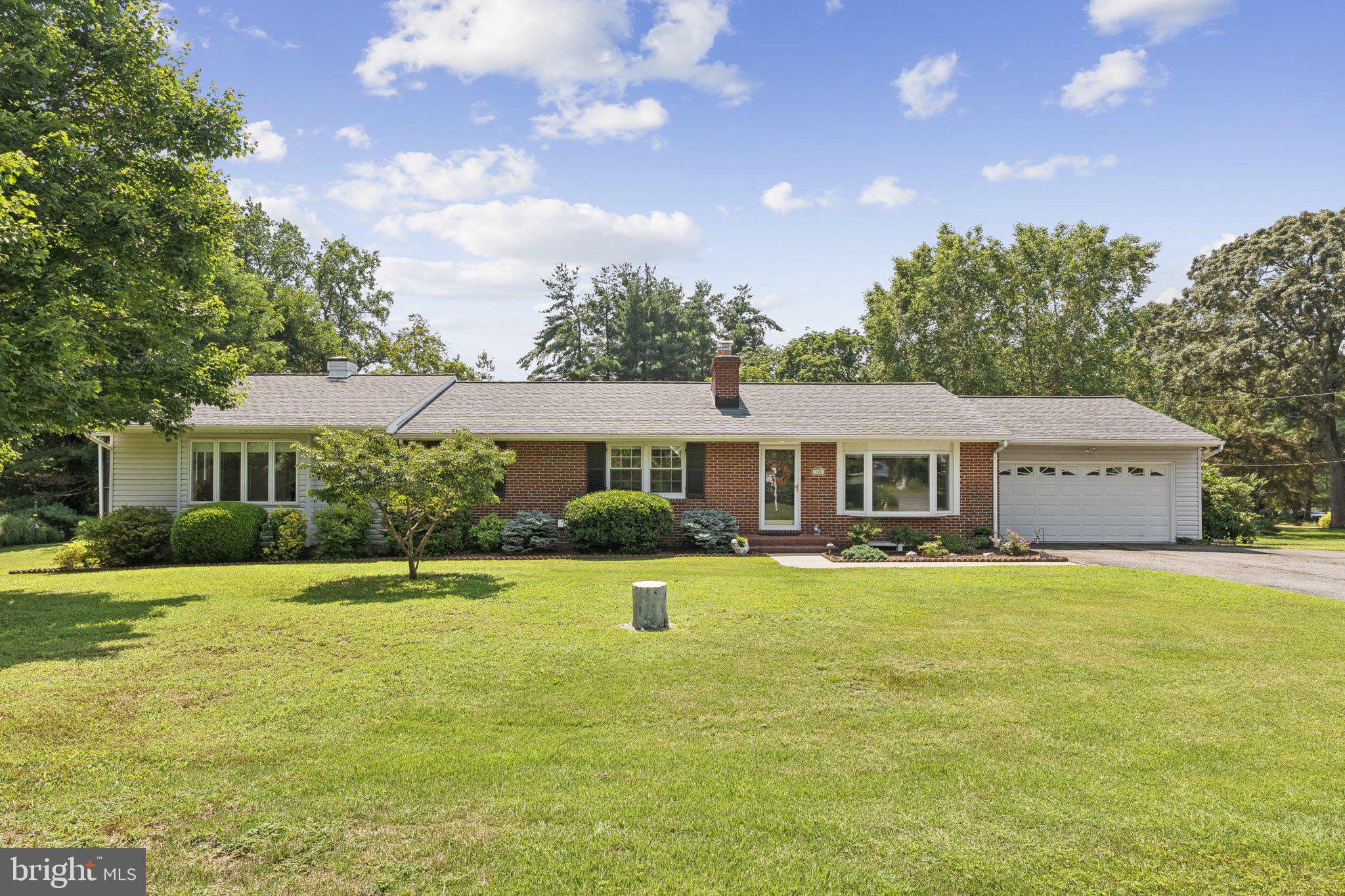 Welcome to your peaceful retreat! Nestled on a lush acre of land in a tranquil water-access neighborhood, this beautifully maintained ranch-style home offers comfort, charm, and space to relax. Step inside to discover gleaming hardwood floors and a warm, inviting living room with custom built-ins and timeless character. The kitchen features rich wood cabinetry and opens to a spacious dining area—perfect for hosting family and friends. A sun-drenched great room with a cozy fireplace becomes the heart of the home, offering views of the surrounding greenery. The home includes three generously sized bedrooms with 2 1/2 baths and a full hall bath, including a stunning primary suite addition complete with a spa-like bathroom that offers the perfect place to unwind. Enjoy morning coffee or evening breezes from the relaxing screened porch overlooking the side yard and a peaceful koi pond. Mature privacy trees and vibrant landscaping enhance the natural beauty and serenity of the property. With community water access and the perfect blend of indoor comfort and outdoor tranquility, this home offers a rare opportunity to live the lifestyle you’ve been dreaming of.