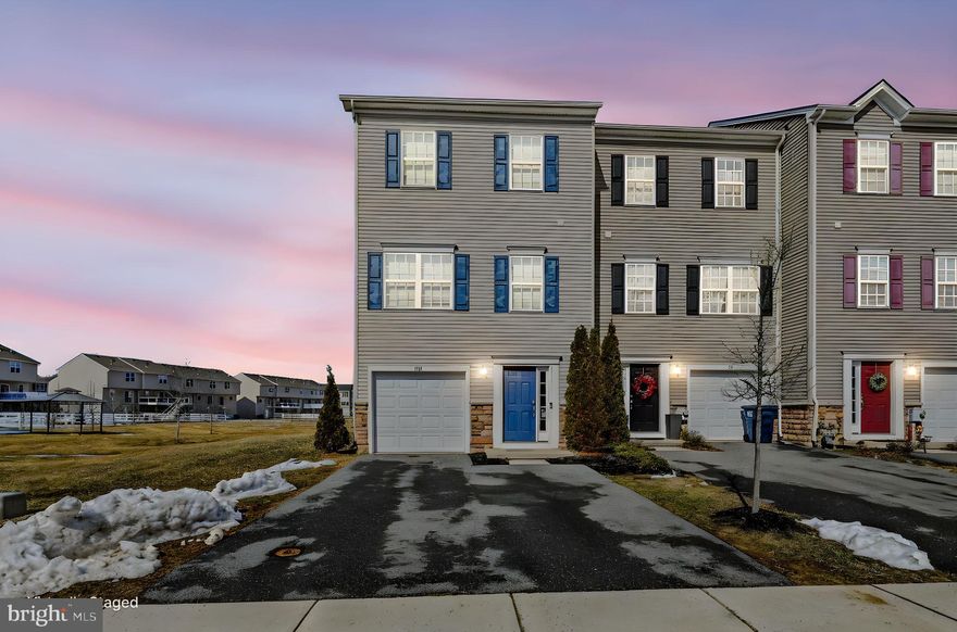 Welcome to this stunning end-unit townhome in the highly desirable community of Hyett's Crossing! This like-new, larger model three-story home offers exceptional natural light, thoughtful design, and modern finishes throughout. The entry level welcomes you with a spacious foyer, providing access to the one-car garage and a rear family room featuring a sliding glass door to the backyard, perfect for additional living space, a home office, or recreation area. This level also includes a utility area and laundry for added convenience. Upstairs on the main living level, you’ll find a bright and open floor plan enhanced by beautiful hardwood flooring throughout. The gourmet kitchen is the heart of the home, showcasing premium white cabinetry, granite countertops, stainless steel appliances, a pantry, and a large island with sink—ideal for entertaining. The dining area sits just off the kitchen, while the front living room features recessed lighting and abundant windows that flood the space with natural light. A convenient half bath completes this level. Toward the rear, a cozy sitting area offers additional gathering space and includes a slider with large side windows for even more natural light. The upper level boasts a spacious primary suite with a private bath featuring dual vanities and a beautifully tiled shower. Two additional front-facing bedrooms share a well-appointed center hall bath. Situated on a premium end-unit lot, this home offers a large, level backyard and side yard area backing to open space, providing added privacy and outdoor enjoyment. Move-in ready and meticulously maintained, this home combines comfort, style, and location in one exceptional opportunity!  Additional upgrades include a new HVAC system!