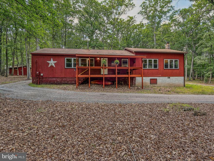 Motivated Seller!  Indulge in the serene ambiance of the Cacapon River community lot!  This home featuring 3 bedrooms, 1 bathroom with washer/dryer, and an open kitchen-dining area with a wood burning stove.  The recently added great room offers ample space for entertaining guests and a wood stove to warm up to when it is chilly outside.  Relish the natural beauty surrounding you on the front covered porch or rear deck. This furnished home also boasts 5.34 acres of lush land, complete with a storage building and children's playhouse.  Enjoy the 6 kayaks (3 tandem & 3 single), paddles and life jackets that also convey.  If you need to work from home you will have the benefits of fiber optic internet!   Explore the possibility of short-term rentals. A perfect blend of relaxation and convenience, this property is suitable for both vacation and full-time living. River Ridge community lot for its residence allowing for access to the Cacapon River – store your kayaks, canoes, and enjoy the picnic area and bathhouse.