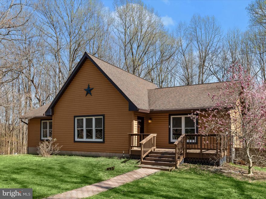 Escape to your own secluded oasis with this stunning, log cabin-style home, nestled on 3.5 wooded acres offering an in-ground heated saltwater pool, soaring cathedral ceiling with a loft in the great room, and a walkout basement with a bath rough-in, just waiting for your customization. Thoughtfully updated, this home boasts a brand-new remodeled kitchen, roof 2017, 8" gutters with leaf guards, HVAC 2019, 22KW whole-house generator in 2022, new windows and sliding door 2023, hot water tank 2023, flooring, newly refinished cedar log exterior, and more!  The cathedral ceiling in the main living area creates a breathtaking sense of space, while the rich, wood  walls and ceiling enhance the home's rustic charm. Overlooking this impressive space is a loft, adding a touch of character and versatility.  The chef's kitchen has been exquisitely remodeled with pristine white quartz countertops, soft-close cabinetry, and stainless steel appliances, including a dual oven glass-top range. Flanked by the dining and breakfast rooms, this space seamlessly flows to the expansive deck, perfect for outdoor dining and entertaining.  The entry-level primary suite is a tranquil retreat, offering a vaulted ceiling, a walk-through closet, and a beautifully updated en suite bath featuring a glass-enclosed shower with decorative tile inlay and dual shower heads. Two additional spacious bedrooms and a well-appointed hall bathroom and laundry room complete this effortless one-level living.  Unleash your creativity in the walkout basement, which includes a bath rough-in, ready to be customized to your exact needs.  Step outside to embrace the serene beauty of nature, whether lounging on the expansive deck or taking a refreshing dip in the heated saltwater pool, surrounded by a lush tree-lined backdrop.  While offering complete privacy, this home is also conveniently located near major commuter routes I-70, Route 40, and Route 32, with easy access to shopping, dining, and entertainment.  Don’t miss this rare opportunity to own a private retreat that seamlessly blends rustic elegance with modern luxury—schedule your showing today!