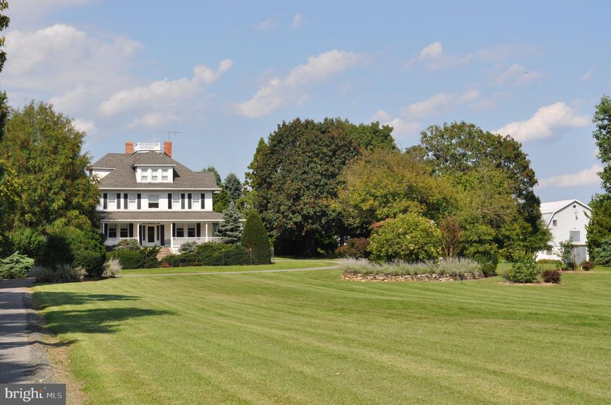 "Mayfield," built in 1916, is a late Victorian home on 10 acres in central Howard County. Its gorgeous setting is enhanced by arboretum -quality landscaping and  stacked stone walls. The property includes two barns, two detached garages, and other outbuildings which can accommodate an office. The house features a wrap-around porch, stained glass insets in doors and transoms, original columns and moldings, English floral carpets and marble floors on the main level, and plaster walls. Full bay windows grace the dining room, family room, and primary bedroom. The second floor includes a primary bedroom suite with sitting room, walk-in closet, private bath, and built-ins, plus three more bedrooms and another full bath. The third floor has a large bedroom -sitting room that takes advantage of the beautiful dormers, another small bedroom or den,  another full bath, and a storage room lined with cedar. The basement is pine-paneled, and has a large recreation room, game area, full bath, storage room, and laundry.  The house has central air conditioning and electric baseboard heat, plus a wood stove for coziness in winter. The house has public water, and the well is used for the barns and gardens. The two barns were built in 1943 for the dairy farm operations. One has been used as an office, and the other for equipment storage. IMPORTANT -- This property is shown by appointment only. Please respect the privacy of the sellers!