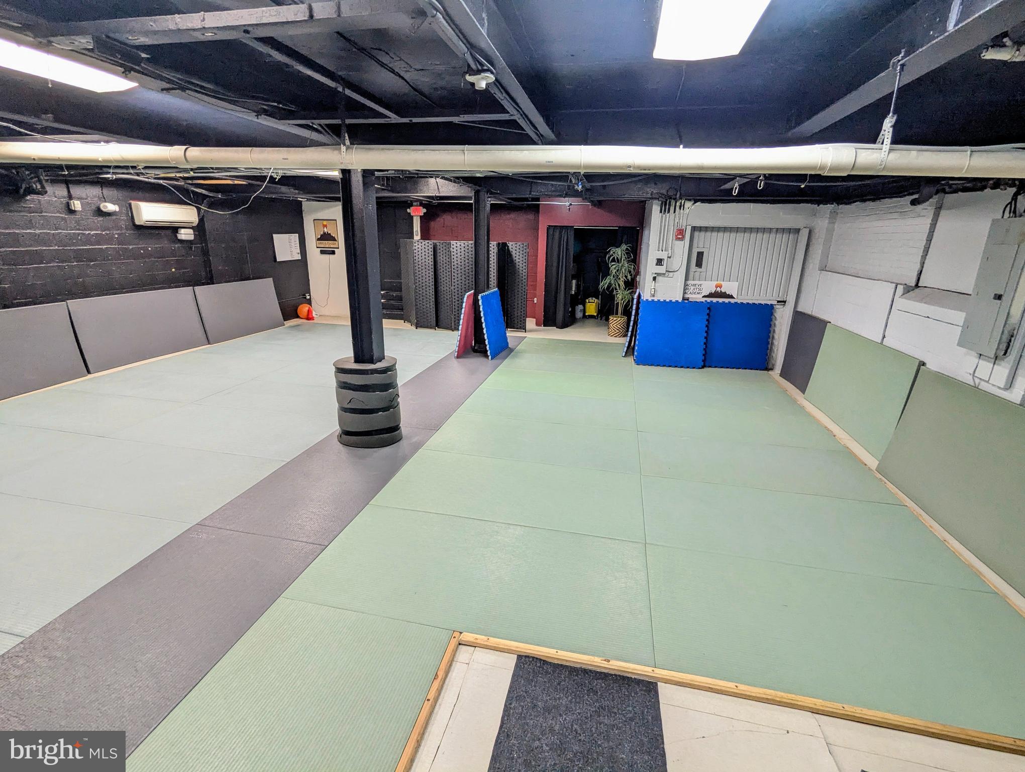Great Flex space suitable for many business use including Gym, Salon, Club, Photography, and similar commercial uses. Mixed Use City zoning.
The space is a large open area with two columns, and ceiling height of Approx 10'. There is a separate storage closet. Space is in the lower level of the building, without windows but does have two exit points. Shared common bathrooms are located on first floor of building.