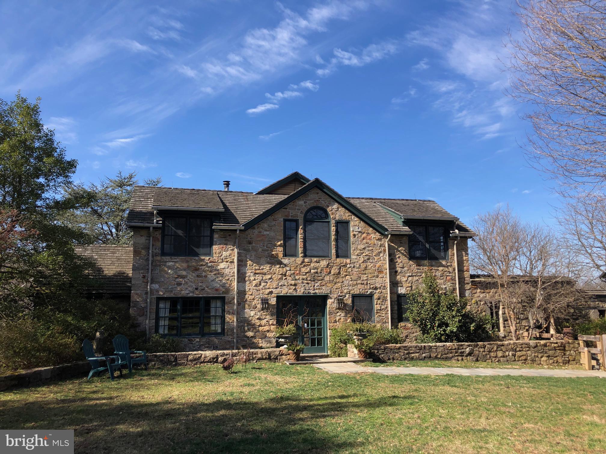 A long, private lane, edged with native plantings and a view of horses, leads you to this sanctuary of a property ideally sited on 17+ picturesque Chester County Acres! with views of lovingly created one-of-a-kind gardens, mature trees & landscaping, private courtyards, manicured gardens & wild spaces. Custom home has a comfortable floor plan, featuring natural light throughout. Start your tour of the home through the front gate along the stone wall. With an eye toward light & detail, the house was designed so you are able to see through from the front of the house to the back, optimizing views & airflow. Double doors open to a warm foyer with terracotta tile floors & powder room. Continue into the cozy living room with a wood fireplace framed by an antique mantle; French doors open onto the grounds. Off the foyer, enter the kitchen, the heart of this home with unique cabinets, generous counter space & ample storage. Featured is a central oversized butcher block island with 2nd sink. Stainless appliances & gas stove make this room a cook s dream. Oversized pantry, laundry/pantry & mudroom with closet complete this area & lead you outside to the breezeway connecting the garage, and a central courtyard. Two steps down from the kitchen, you enter the formal dining area with sliding doors to the grounds and wood burning fireplace with beautiful wood mantle. A raised ceiling with skylights provides additional light to this beautiful room. Down the hall from the foyer find the library/office, a quiet spot lined with bookshelves, a perfect office or sitting room to while away hours on the window seat with a good book. Farther down the hall find a light-flooded family room with beautiful natural light and French doors opening to the grounds. There is an amazing indoor greenhouse, connecting to the living room, a lush space year round. Upstairs, you will find the spacious master suite with great light and French door to balcony view of the amazing grounds. Sumptuous ensuite bath with soaking tub, oversized walk-in shower. Two additional bedrooms, connected by a Jack & Jill shower with private sink areas, complete the second floor. Throughout the home, upgraded materials include beautiful wood floors, custom millwork & oversized windows for great natural light. Full basement with Bilco doors to exterior. From the oversized parking area, enter through the stone archways to a beautiful breezeway boasting views of the stunning internal courtyard. Side door to the kitchen is here or enter the oversized two car garage. Follow the breezeway to find the studio/guest house. The first floor studio space has many potential uses - artist studio, private office or entertainment space. Climb the spiral staircase to the second floor guest space with full bath. Beautiful views and natural light make this the kind of space guests will walk into & never want to leave. Studio could easily be converted into small kitchen & living area. Stepping outside from any door of the house you are greeted with picturesque views of the grounds. Relax at the unique brick pool w/Olympic sized lap area & deep end for diving, enjoying views overlooking the extended property which features two ponds, a beautiful stream & 8 acres of mature woods. All the plantings have been lovingly curated to create tranquil seating areas; there are simply too many unique landscapes to mention! Property outbuildings include a large barn w/greenhouse, stalls, tackroom, tractor or garage parking. Stairs to 2nd level for hay storage or workshop. Bring your horses; several stalls open to fenced pasture & paddock space. Custom 9 x 14 garden shed including a 14 TREX workbench & TREX floors. Whole house generator powers the property as needed. Location is private yet convenient to all amenities and for an easy commute! An offering like like this Chester County estate property is rare so don t miss the opportunity to make this unique property your forever home!
