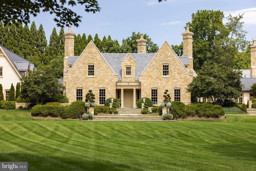 Set among the rolling hills of Great Falls, Alderley Manor is an estate on five acres, inspired by European traditions. The grounds evoke the English Cotswolds, where light-stone manors rise above open expanses and long vistas.

The residence was a collaboration between David Cooper of ACG Architects and BOWA Construction, with further enhancements by Hanlon Design Build. Spanning more than 20,000 square feet, the estate showcases exceptional craftsmanship, timeless style, and premier amenities. A pea stone driveway leads to a central flagstone motor court, where imported Cotswold limestone, a slate roof with metal seams, copper gutters, and freshly repainted woodwork set a tone of enduring grandeur. Classic symmetry, steep gables, and towering chimneys create a striking first impression, balanced by warmth. Every exterior window and door is framed in rich mahogany, underscoring the commitment to quality and authenticity.

Inside, reclaimed antique oak floors and hand-finished millwork reflect the same meticulous standards. Formal and informal rooms are proportioned to feel both expansive and inviting. Exquisite moldings, hand-carved details, custom built-ins, and oversized fireplace mantels with marble hearths enrich the interiors. The layout maintains symmetry while allowing a natural, intuitive flow. Top-tier finishes and fixtures support both grand-scale entertaining and daily living.

The main level features elegant formal rooms, including a moody library with deep green built-ins and bold ceiling wallpaper, and a light-filled main gallery connecting the east and west wings. Informal spaces center around the chef’s kitchen with twin islands, furniture-grade cabinetry, a Lacanche range, and artisanal tilework. The adjacent breakfast room, with exposed beams, a stone accent wall, and multiple French doors, opens to the grounds. The west wing is dedicated to the primary suite, with a private garden, sitting room, dual dressing wings, and two luxurious baths. Two offices, including one with a vaulted beamed ceiling, complete the level.

Upstairs, four bedrooms each showcase a unique design sensibility and are served by Lagos Azul limestone baths with Waterworks fixtures. The lower level is designed for leisure and entertaining, with a transverse gallery leading to a professional cinema, climate-controlled wine cellar, and a fitness center with spa bath, steam shower, and cold plunge, plus billiards and art studio spaces. Behind the scenes, commercial-grade systems ensure seamless living, including a self-sustaining well and septic, whole-house generator, Lutron lighting, smart HVAC, and a comprehensive security system.

Outdoors, the gardens are extraordinary. With an investment exceeding eight figures, the landscaping and horticulture reach a world-class standard, creating a tapestry of manicured gardens, mature trees, and seasonal blooms. The setting is fully irrigated and softly illuminated by custom landscape lighting with hundreds of concealed fixtures that bring the property to life after dark. A heated lap pool with a retractable cover, a pergola-covered dining terrace, and a newly installed sports court provide exceptional opportunities for recreation and relaxation. For the automotive enthusiast, a modern farmhouse-style garage offers three bays, two lifts, a mezzanine lounge, and a cigar bar.

While secluded, Alderley Manor is less than a mile from Great Falls Village and minutes from Tysons Corner, the Reston Tech Corridor, and Washington, D.C.

With its rare combination of space, craftsmanship, architectural integrity, and refined amenities, Alderley Manor ranks among the region’s most exceptional private estates.