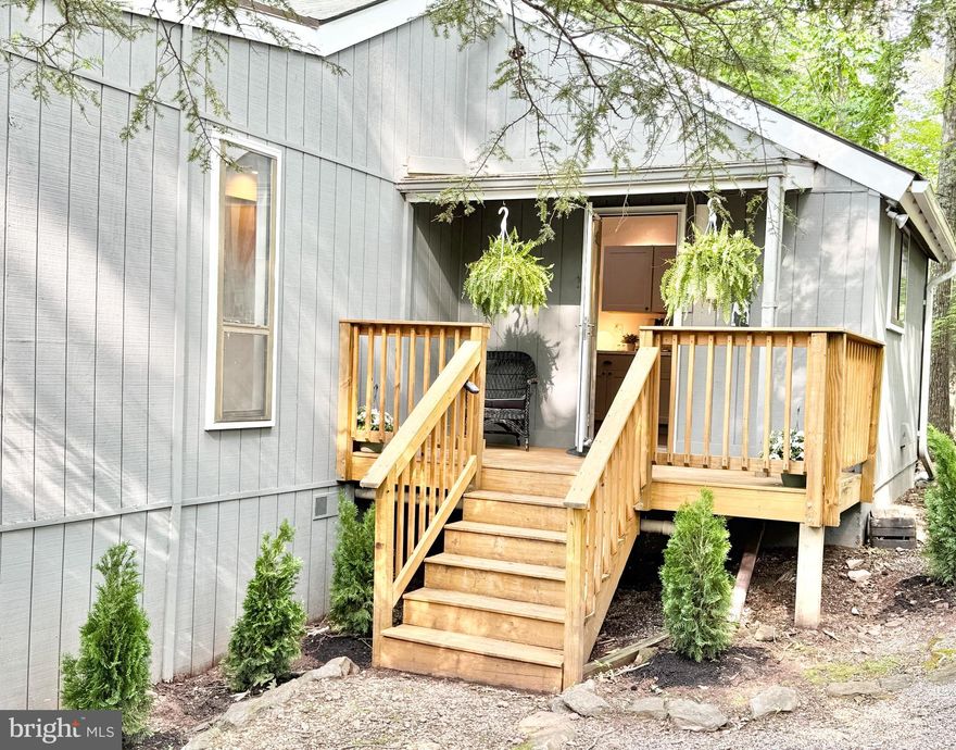Nestled in the treetops on just over an acre, this private woodland retreat offers all the treehouse vibes—and all modern updates to match. From the spacious decks and screened-in porch, you can relax to the soothing sounds of a seasonal stream nearby, surrounded by peaceful nature.

Inside, this beautifully updated 2-bedroom, 2-bath home with a loft combines cozy charm and stylish updates. At its heart is a stunning stone, wood-burning fireplace, framed by natural light from two skylights and windows all around, creating a warm, inviting space year-round.

The open layout feels expansive and bright, with thoughtful updates throughout, including:

New luxury vinyl plank and tile flooring

Sleek, modern LVP, cable-and-metal staircase to the loft

All-new lighting and bathroom fixtures.

Stylish kitchen renovation with new cabinetry, countertops, and Samsung Bespoke stainless steel appliances, including an induction oven, vent hood, dishwasher, and double-door fridge with ice maker and water dispenser—all under warranty

The reimagined laundry and pantry space is a standout, featuring a high-capacity Samsung washer and dryer, built-in storage, and plenty of room for pantry essentials. Storage is plentiful with three additional closets, plus extra space in the crawlspace for hobbies and gear.

The versatile loft, once used as a bedroom, now serves as a bright and airy office, ideal for remote work or creative projects.

This home has been lovingly maintained and was inspected in May 2025.  Septic was also tested and pumped in May. The roof is only five years old, installed by the previous owner.  

A Class B membership is available, offering access to a wide range of private club amenities for a $3,150 initiation fee and $1,250 annual dues (not included in HOA fees). Amenities include:

Indoor Sports Center with racquetball, pool, gym, aerobics studio, sauna, steam room, whirlpool, volleyball, basketball, and pickleball

Two Outdoor pools

Baseball field, playground, and fishing ponds