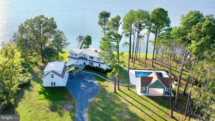 The Ultimate Harris Creek Retreat—Unrivaled Views. Room to Spread Out. Sunsets You’ll Never Forget.  

Welcome to your family’s forever getaway: a fully renovated waterfront estate on 2.4 acres with 240+ feet of direct water frontage. Perfectly positioned for stunning western views over Harris Creek, this exceptional property includes a reimagined main residence, newly constructed three-bay garage with guest suite, and a thoughtfully designed pool house for seamless indoor-outdoor living.

Enjoy water views from nearly every room. Inside, a welcoming foyer leads to a dramatic great room with panoramic vistas and open flow ideal for entertaining. The sleek kitchen features an oversized island, 48” fridge, six-burner range, drawer microwave, beverage cooler, and ample cabinetry. A cozy fireside game room and a whimsical nautical-themed powder room add charm. A main-level bedroom with en-suite bath offers comfort for guests or those with mobility needs.

Step outside to a large WearDeck composite deck with views of the new 100’ pier, 10,000 lb boat lift, and jet ski lifts. The approx. 3-ft MLW (buyer to verify) allows for a variety of watercraft. Spend your days tubing, water skiing, or fishing from your backyard.

Upstairs, the expansive primary suite spans nearly the full width of the home, with tranquil water views, spa-style bath, walk-in closet, and space for a future sixth bedroom (once public sewer arrives, expected in 2026). Two additional bedrooms—one en-suite and one with shared bath—plus laundry complete the upper level. Nearly every bedroom offers views of the water or pool.

The brand-new 40' x 20' pool features a sunning ledge, bubbler, automatic cover, and is pre-plumbed for a slide. The pool house adds a full bath, kitchenette, lounge area, and pool equipment/storage room with room for a future heater.

The detached garage offers even more flexibility: a finished guest suite with en-suite bath, mini-split HVAC, and wet bar rough-in. The lower garage level—also with water views—makes an ideal workshop, studio, or creative space.

With an elevated lot above the floodplain, new 5-bedroom BAT septic system, and anticipated sewer connection, this home is future-ready. All systems have been updated: dual-zone HVAC, electrical, plumbing, and roof. Exterior upgrades include Hardiplank siding, composite trim, and low-maintenance decking.

A new tar-and-chip road adds smooth, low-maintenance access, rounding out the property’s turnkey appeal.

Set along the revitalized shores of Harris Creek—home to the largest oyster restoration project in Chesapeake Bay history—this legacy retreat blends eco-conscious living with timeless waterfront luxury.