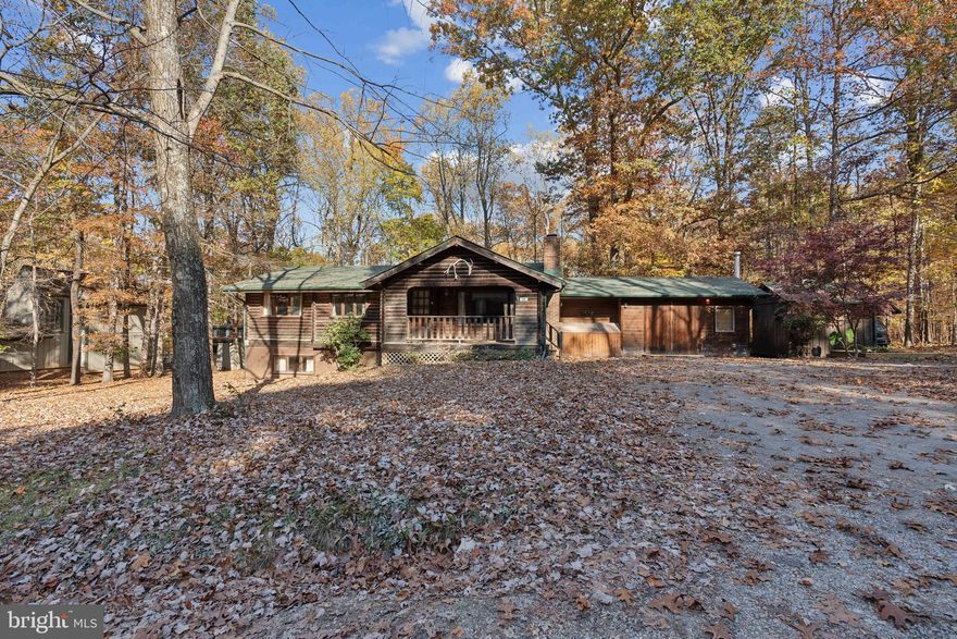 Nestled on a scenic wooded lot, this inviting- main level living- log cabin offers comfort, charm, and versatility. From the vaulted ceilings in the family room to the  stone wood burning fireplace  and  the antler chandelier in the dining area, this home has so much character. A newly updated kitchen with new granite counters,  stainless steal double sink, a  dishwasher, stainless french door refrigerator with deli drawer and bottom freezer,  stove and new range hood, 
3 bedrooms - currently used as 2 bedrooms and an office with High speed xfinity internet.  New vinyl plank flooring on the main level.  1 full bath on main level with new flooring. Separate laundry room  and pantry cabinet off the kitchen. Central air and heat on main level.  Enjoy views from  the kitchen window of the  large  back deck overlooking the private wooded yard.. You will love the  spacious attached  workshop  that is heated with a wood stove and cooled with a  window unit for year round use- it has direct access via the  interior door  or double exterior door access off the driveway.    The mostly finished basement is primed for your personal touches, making it perfect for additional living space or entertainment areas with a half bath.  Heated with a wood stove with pass thru vents to the main level that allow you to fire up the wood stove in the basement  to add supplemental heat to the main level.   Relax on the covered front porch, perfect for taking in the peaceful, wooded surroundings or the expansive back deck.  1 car carport. covered parking, Additional features include a circular drive for easy access,  a machine shed,  a detached storage shed and a chicken coop.  So much to see.  Only 2 miles to Rt 7 for easy commuting and fast access to Rt 7 in Bluemont super close to the Loudoun County line but you get cheaper taxes. NO HOA  ( note: electric baseboard are not in use and can be removed- central heat/ air are in the home. )