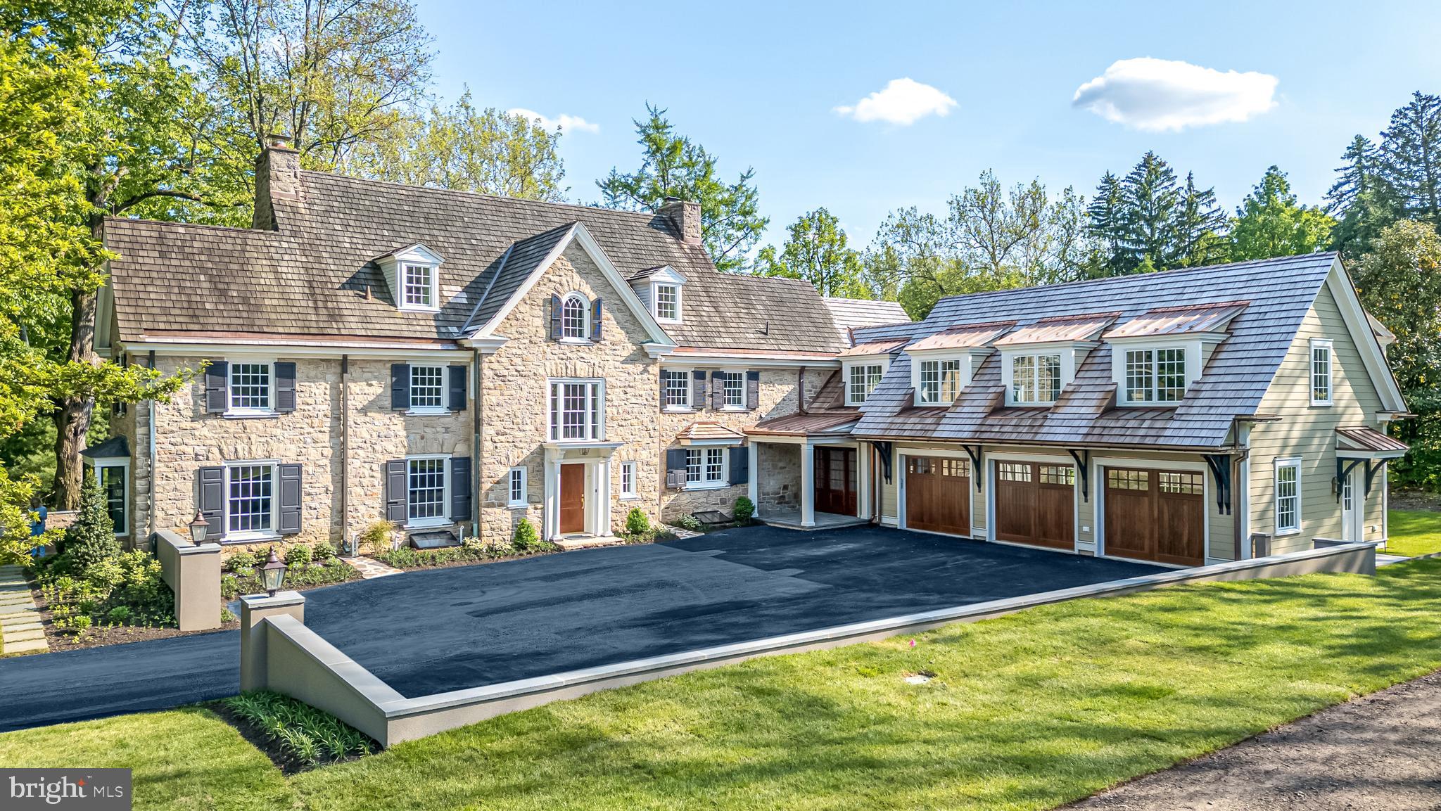 Nestled in the embrace of time-honored trees in the heart of Blue Bell, offering unparalleled views of permanently conserved open space with horse & walking trails, and once the site of George Washington’s encampment, this completely renovated 5 bedroom, 7 bath Stone Colonial stands as a testament to timeless elegance & meticulous craftsmanship. Every element of this extraordinary home, originally built in 1910, from the gleaming new hardwood floors, to the spectacular kitchen & gorgeous en-suite Baths, has been reimagined and transformed while still blending seamlessly with its history & character. Everything is new, including the walls, windows, doors, electrical system, HVAC, tankless hot water heater, septic system, plumbing & lighting fixtures and more. Perhaps the crowning jewel of this renovated gem is its addition, an attached 3-car garage w/rooms above, designed to complement rather than compete by successfully enhancing the home's functionality while preserving its historic charm. A long tree-lined private lane leads to the newly created, walled courtyard entrance. The 12” thick stone walls, cedar shake roof, copper gutters, deep windowsills, arched doorways & 9’ 1st floor ceilings preserve the home’s integral character. 2 separate entrances include a custom solid mahogany front door opening to the center hall with a curved 3-story staircase whispering stories of the past. The center hall provides a breathtaking front-to-back view of the rear grounds through the impressive floor-to-ceiling rear French doors that extend across the Living & Dining Rms. The meticulously created Kitchen is a work of art where every detail of this extraordinary culinary space has been carefully crafted, including quartz counters, farm sink, stunning tiled backsplash, commercial range, 1 of 2 dishwashers, furniture-style refrigerator & freezer, expansive center island w/walnut butcher block counter w/seating for 4 & bar w/wine refrigerator. Enjoy the cuisine in the adjacent Dining Rm while basking in the warmth of the gas fireplace. The ease of entertaining is enhanced by the adjacent Butler’s Pantry w/2nd dishwasher, 2nd sink & walls lined w/custom cabinetry. The incredibly spacious Living Rm features the 2nd gas fireplace & offers the opportunity for multiple seating areas. A connecting Study provides one of the most spectacular views of the exterior. The 2 Powder Rms are simply gorgeous. Completing this level is a spacious Mud Room. 2 sets of stairs provide access to the 2nd floor. Pure luxury awaits in the Primary Ste w/walk-in, professionally organized closet & a sensational Full Bath w/radiant heated flr, stand-alone tub, double vanities w/quartz counters & & spa-worthy walk-in shower w/glass wall. 3 additional bedrms & en-suite baths are equally impressive, each offering its own unique blend of comfort & style. A separate Family Rm on this level offers options for Media or Recreation, & the Laundry Rm includes a washer, dryer, utility sink & custom cabinetry. Continuing to the 3rd level will reveal 1 charming Bedrm & a Gym, sharing a stunning Full Bath. Doors from every 1st floor rm provide access to the grounds, where nature takes center stage, w/conserved space providing a backdrop of lush greenery as far as the eye can see. Whether reading a book on the stone terrace or brick patio or barbecuing at the outdoor kitchen, the views are breathtaking and private. Horse lovers will have the added bonus of access to the Green Ribbon trail. Other significant features include Sonos system w/speakers in every room, a security system & backup generator. This special retreat is 5 minutes to the charming shops & restaurants of Ambler & close to multiple train stations w/easy access to center city Phila. Located within top-rated Wissahickon School District, & minutes to excellent private schools including GA. This is not just a house, but a masterpiece of design & craftsmanship, where past & present converge in perfect harmony.