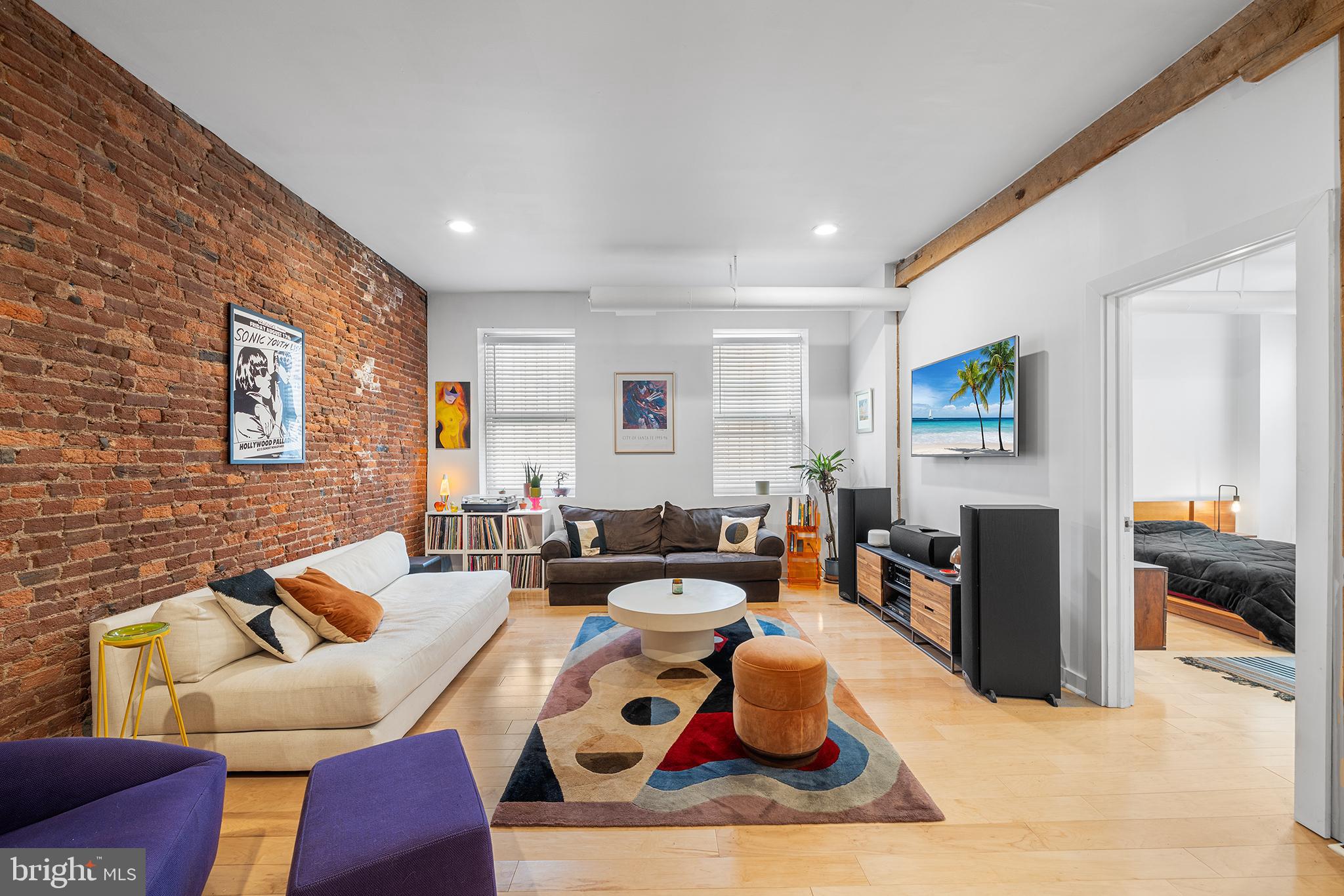 Tucked in Historic Headhouse Square down a cobblestone alley, this character-rich loft is the urban hideaway you've been dreaming of. Unit A blends industrial vibes and warm textures—exposed brick walls, soaring ceilings, and wide-open space just begging for your creative touch.
This 2-bedroom, 1-bath condo is quietly bold, with its own secured, COVERED PARKING SPOT (a rare gem in Philly). Step through the private carport entrance and right into the building—no stairs, no hassle.
Inside, you’re greeted by a stunningly open layout that’s equal parts gallery, studio, and sanctuary. Imagine a long table for dinner parties, a studio corner for painting or photography, or a full-on vinyl-listening lounge. The modern galley kitchen keeps things sleek and efficient, while just beyond, a second open living area features a wood-burning fireplace and oversized windows keeping the ambiance grounded in the best way.
The primary bedroom offers space to breathe, with two big windows, a full closet, and room for your dream setup. The adjacent bath includes a stacked washer/dryer, tiled shower/tub, and water closet, all in a smart circular flow that feels intuitive and easy.
A second room just off the entryway makes the perfect guest room, home gym, or creative workspace—whatever your lifestyle calls for.
Location-wise, you’re in the sweet spot: walkable to Queen Village, Old City, and the Delaware River waterfront, surrounded by galleries, boutiques, and some of the best food scenes in the city. Plus, you’ve got easy access to public transit and major highways when you need to get out of town.
This is more than a condo—it’s a canvas. Come make it your own.