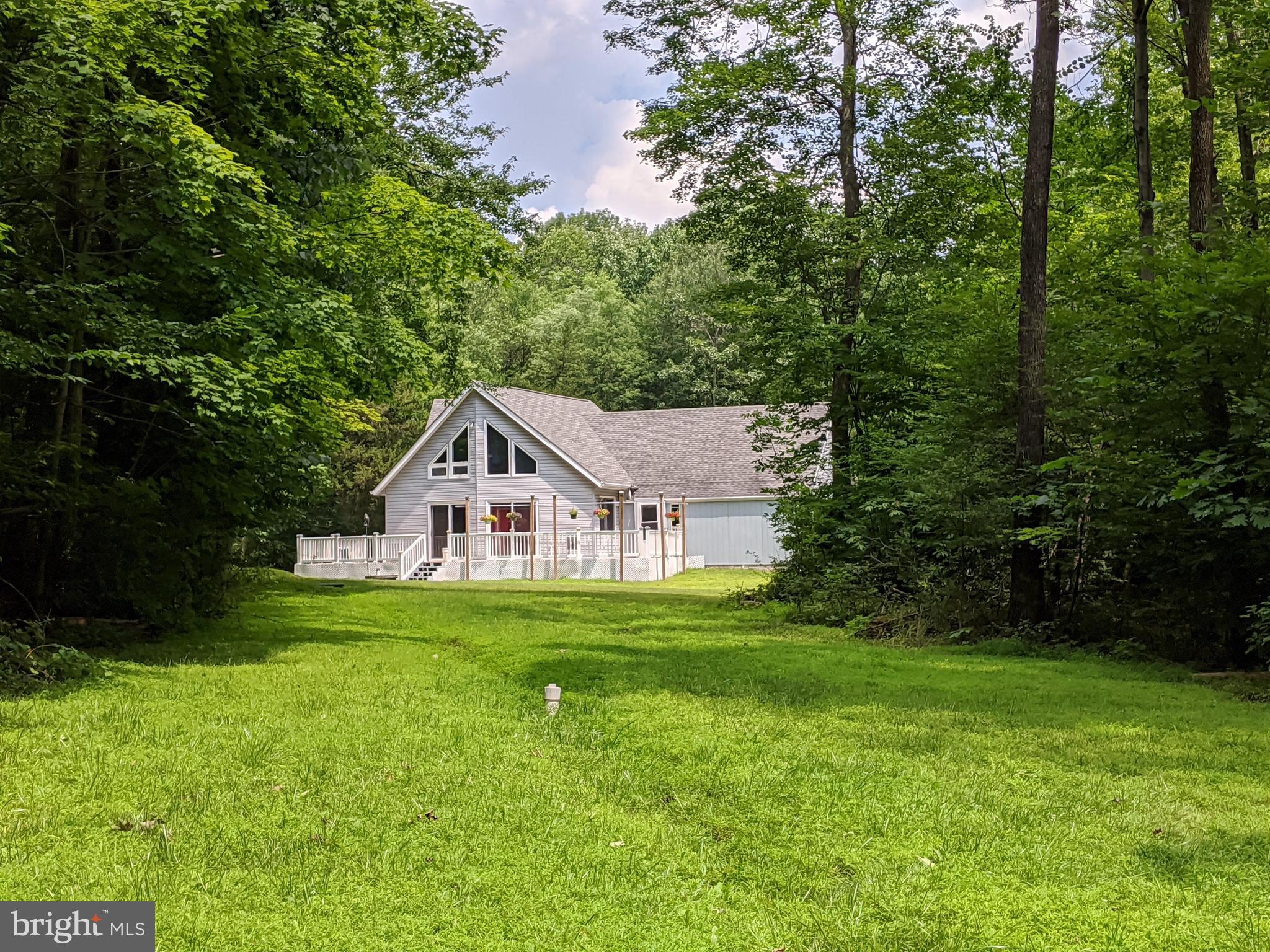 Escape the hustle and bustle of the city in your own, custom built Chalet style home.   Situated on over 10  beautifully treed and peaceful acres.   Hike and climb on your own trails or spend time relaxing by your own babbling creek/stream.   Maybe you would enjoy playing  disc golf on your own ten hole course.  After a long day how incredible it will be to watch the sunset on your large deck, listening to the birds sing or just hearing nothing but the peaceful sounds of nature.  You may even want to spend time in your large raised bed gardens protected by electrical fencing.  Then you can rinse off under your outdoor shower!  When you enter the Chalet under the covered breezeway you immediately feel on vacation in the Alps of Switzerland.  Cuddle up with a book in the  cozy inviting living area which includes  a pellet stove, providing extra warmth and ambiance in the winter months.  Or maybe you would like to cook your meals  and garden harvests in your updated stainless steel and tiled kitchen.  Eat in or eat outside on your deck.  2 main floor bedrooms with full bath and plenty of storage space. Additional bedroom on second floor with another full bath and an  open loft.  Every inch of this Chalet has been well cared for and maintained.  It's just a few  miles from Routes 563, 309, 63, and 29 making this a great accessible point for travel in all directions.    This is your opportunity to live in a one- of -a- kind  custom built home surrounded by a spectacular setting.  Let your imagination and dreams run wild and come true.  The possibilities are endless for this personal retreat to call your own!