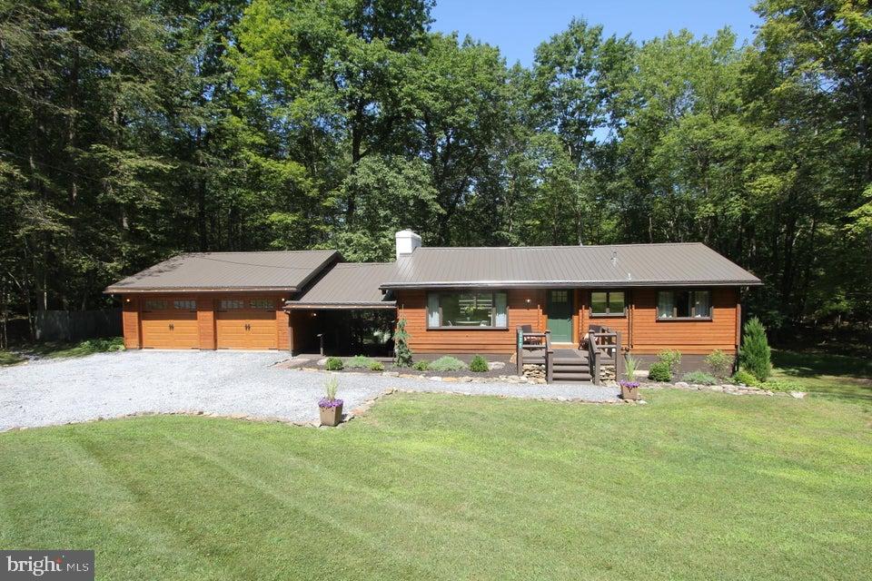 Discover this charming 3-bedroom, 2-bathroom cabin in the heart of Treasure Lake, perfectly situated on a quiet cul-de-sac. A 2-car garage, connected by a breezeway, adds both convenience and character. Inside, modern updates blend seamlessly with warm country charm. The main floor features two bedrooms, an office space, and a bright living room that opens onto a spacious back deck— perfect for relaxing or entertaining. The deck overlooks an expansive backyard, ideal for outdoor activities and enjoying the serene surroundings. The lower level offers a private retreat with a bedroom, full bathroom, and a kitchenette, along with a walk-out to the backyard great for guests or multi-generational living. Treasure Lake offers a resort-style lifestyle with lakes, beaches, golf courses, and more right at your doorstep. Whether you're seeking a full-time residence or a weekend getaway, this beautifully updated home is ready to welcome you.