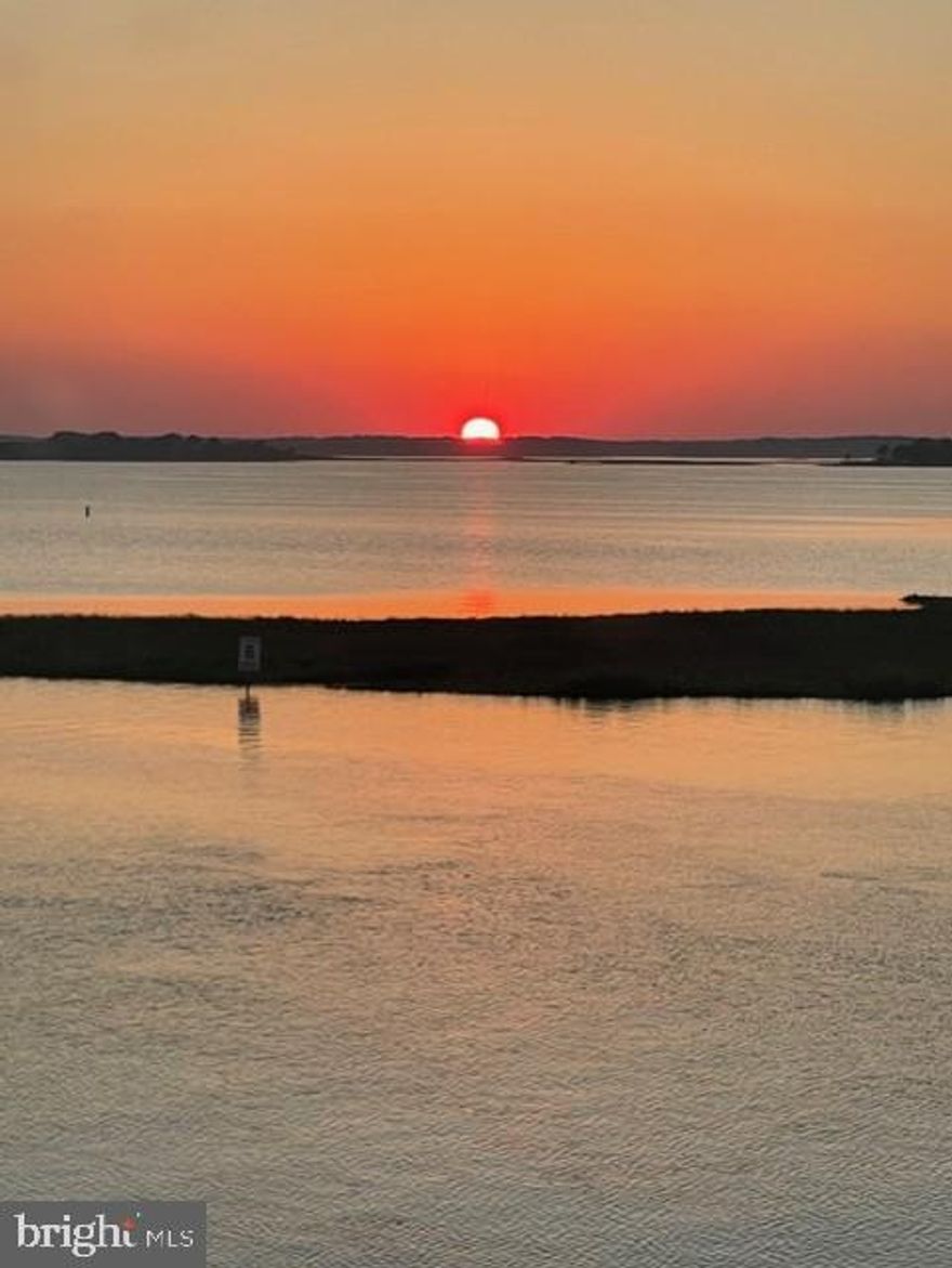 Don’t miss this incredible opportunity to own a rarely available 3BR/3BA bayfront townhome in North Ocean City featuring two deeded boat slips, a two-car garage, and breathtaking sunset views over deep water.  From the moment you walk in the front door, you’ll be captivated by panoramic bay views that stretch in both directions. The first floor features a beautiful bayfront bedroom with an upgraded full bath and a second family room that opens to a wraparound deck — perfect for relaxing or entertaining by the water. The main living level boasts a spacious family room with stunning bay views that flow seamlessly into an expansive gourmet kitchen — complete with a bar area, large pantry, abundant cabinet space, and granite countertops. A chef’s delight! The dining area overlooks the bay, and the deck off the family room provides the ideal spot to enjoy cool breezes and memorable crab feasts. Upstairs, you’ll find a guest bedroom with a private en suite bath featuring a stall shower and large walk-in closet. The primary suite is a true retreat — spacious and overlooking the bay, with a spa-like bath including an upgraded shower, soaking tub, and a huge walk-in closet. For the boating enthusiast, this home is a dream come true with two deeded boat slips, a dock, stee bulkhead and a pier for easy access to open water.  Experience some of the best fishing in Ocean City off the pier at the Fenwick Ditch.  The two-car garage provides plenty of storage for all your beach and boating gear. Conveniently located close to restaurants, shops, and Fenwick Island, this is coastal living at its best!