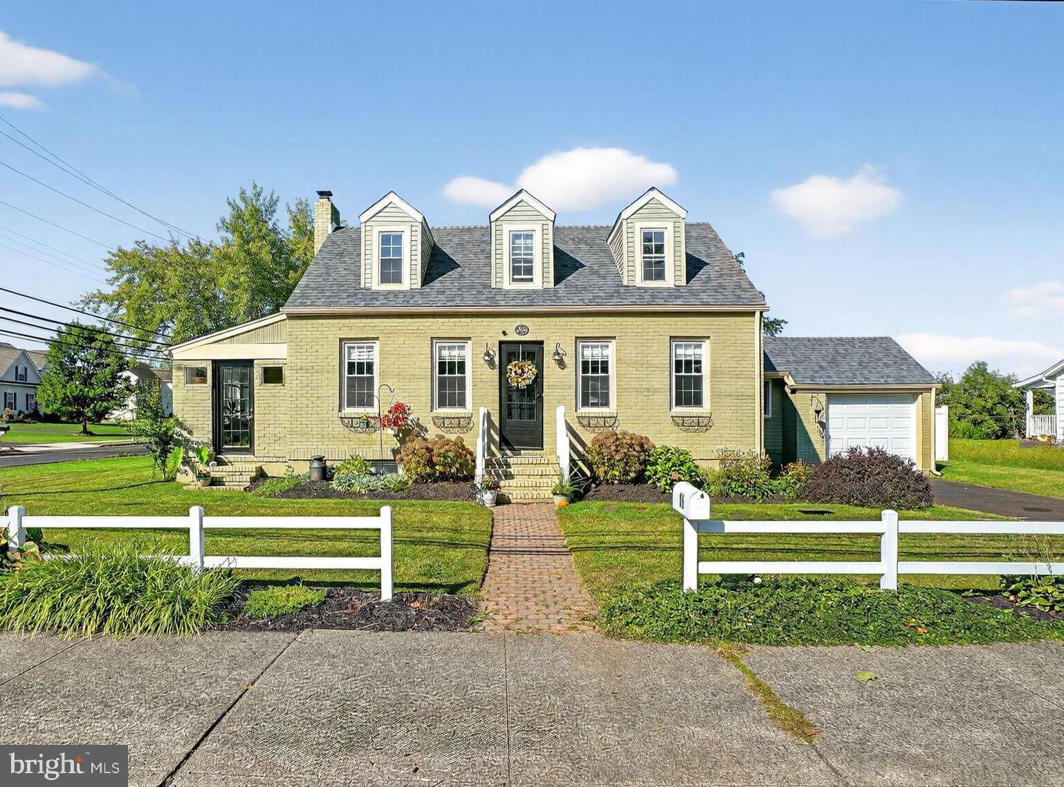 Deceivingly larger than it appears from the street, this charming cape offers a main floor bedroom and bath--downsizers take note! The focal point of the living room is a stunning stone gas fireplace which is flanked by built-in bookshelves. The dining room has a lovely corner cabinet, crown molding and wainscoting. Bright with many windows and a French door, the sunroom is an ideal out-of-the way reading or play room. The kitchen offers ample cabinets, crown molding, tile backsplash and a farm sink. Opening the French door off the kitchen, you will step into the laundry/mud room which highlights a sizable counter for folding laundry and useful cabinets underneath for storage. Noteworthy is the appealing yet very practical bench seat with storage underneath for boots, shoes or bookbags. This bench seat is below a cheery bay window where your houseplants will be spoiled by the large windowsill. Three additional bedrooms, all with hardwood floors and some with built-ins, and an updated full bathroom can be found on the 2nd floor. The fenced-in huge backyard has a delightful patio and bar for outdoor entertaining. The full basement, garage and backyard shed will handle all your storage needs. This home is in a fabulous location, right around the corner from the Y and a short stroll into Quakertown Boro, making it easy to visit all the popular eateries and breweries. Special features include newer roof, hardwood flooring throughout most of the home, quaint arched hallways, custom radiator covers and a newer water conditioner, refrigerator and dryer. The fortunate new homeowner will have the comfort of knowing this property is covered by America’s Preferred One Year Home Warranty.