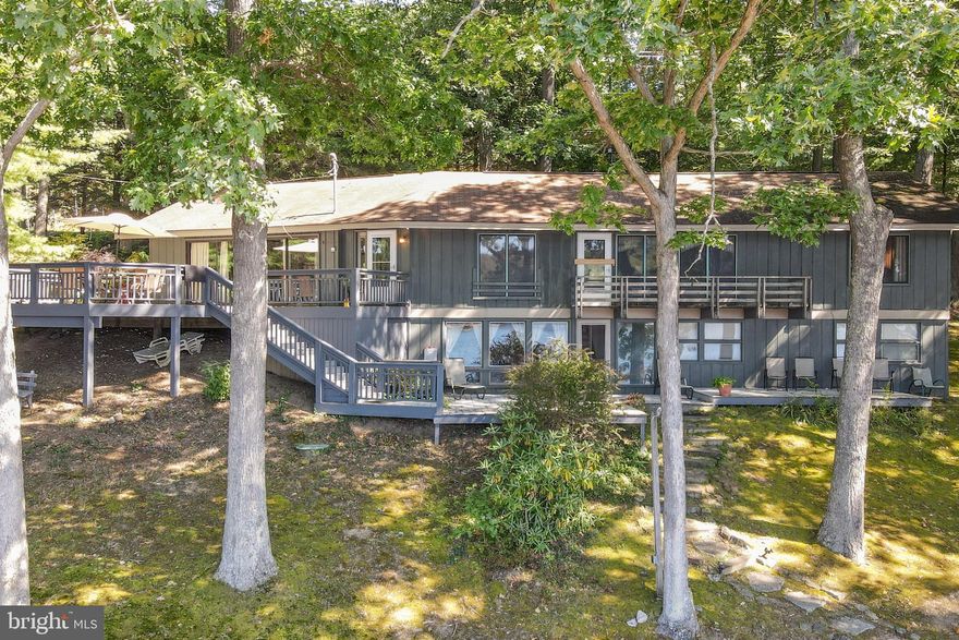 Unparalleled 312 feet of pristine waterfront on Deep Creek Lake with ideal western exposure for breathtaking daily sunsets. This inviting 4-bedroom lakeside retreat features a permitted private Type A dock, public sewer for low-maintenance ownership, and spacious living areas designed for effortless entertaining and relaxation with seamless indoor-outdoor flow. Expansive windows that flood every room with natural light, creating the breathtaking sensation of living right on top of the lake. Entertain your loved ones in the spacious living and family rooms or outside on the expansive deck space. The beautiful stone wood-burning fireplace will be a centerpiece for never-ending fun evenings. With no HOA and a prime location just minutes from Deep Creek Lake State Park, Arrowhead Market, the lively Honi Honi Bar, and numerous restaurants and amenities, this property delivers peaceful waterfront living combined with exceptional convenience—making it ideal for full-time residence, weekend escapes, or highly desirable vacation rentals in the Deep Creek Lake area. A rare opportunity to own substantial private shoreline and enjoy the ultimate lakeside lifestyle. Call for more details or to schedule your private showing today!