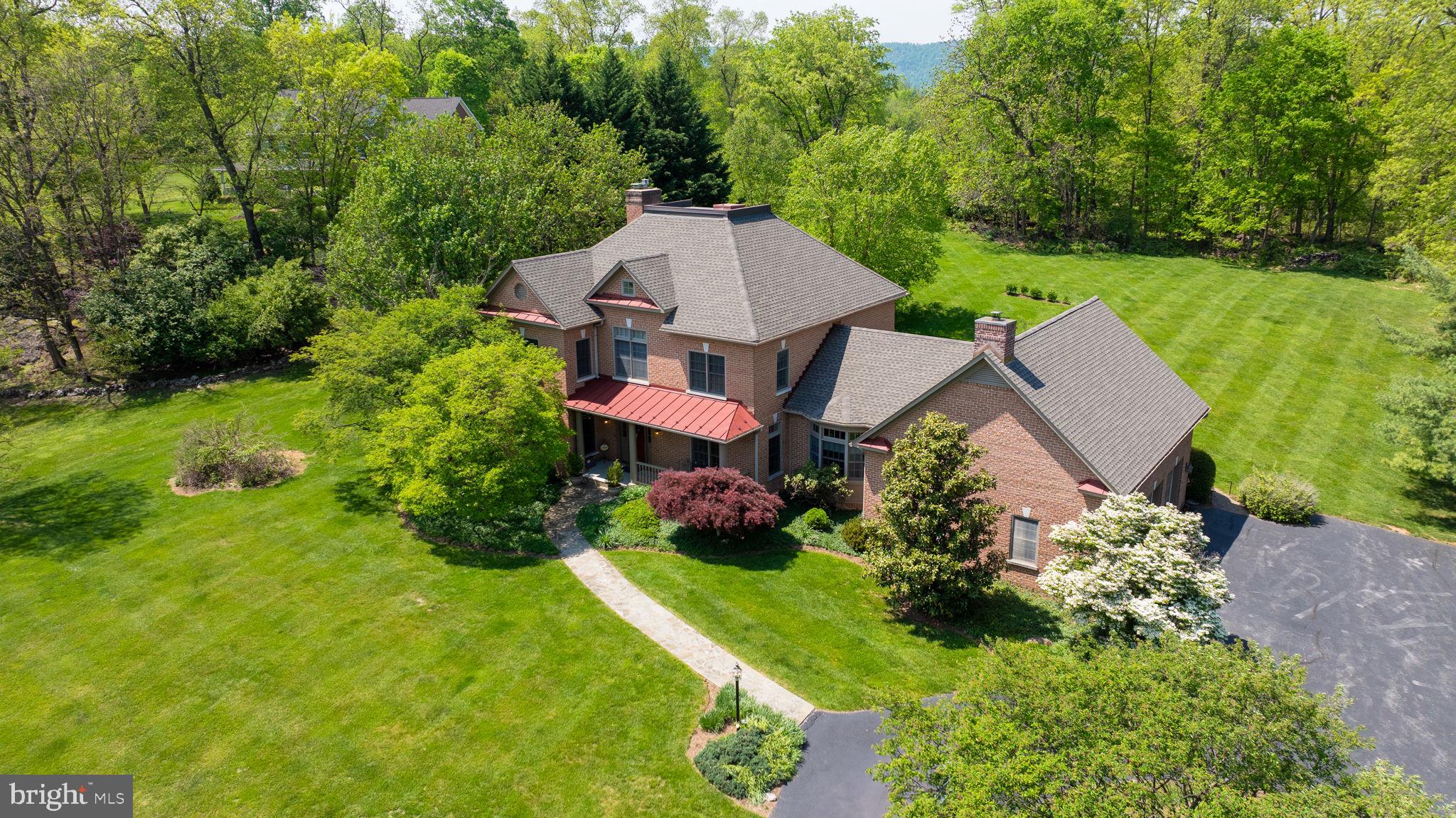 Tucked away at the end of a long, winding driveway, this solid brick custom home offers privacy, charm, and endless space to enjoy. Set on a beautifully landscaped lot with well-maintained gardens, the property boasts a large backyard, a spacious deck with a pergola, and ample patio space perfect for entertaining.
Step inside to a grand entryway that sets the tone for the rest of the home—complete with hardwood floors, a stylish half bath tucked under the stairs, a formal dining room, and a welcoming front living room. The main level continues to impress with a full kitchen featuring a massive island, a walk-in pantry, and a cozy breakfast area that opens into a light-filled sunroom overlooking the back deck. Adjacent to the kitchen is a built-in desk space , offering a convenient work nook and large family room with stone fireplace.
Down the hall, you'll find a second full bath, a walk-in closet, and a private office. The home spans three levels (with a crawl space below), and the upper two levels are carpeted for added comfort.
Upstairs, the second floor hosts four bedrooms and three full baths. Two bedrooms share a Jack-and-Jill bath, while the third guest bedroom enjoys its own en suite bath and walk-in closet. The master suite is a peaceful retreat with his-and-hers closets, built-in storage, a bay window, and a spacious double vanity bath with a soaking tub.
Additional features include two extra storage rooms—one behind a bedroom and one unfinished room above the garage, accessible through the first. The third floor features a large open bonus room, perfect for a playroom, media space, or home gym. Three car attched garage will accomodate all your vehichles.
Flooded with natural light thanks to generous windows in every room, this home is a must-see for those who value both beauty and functionality.