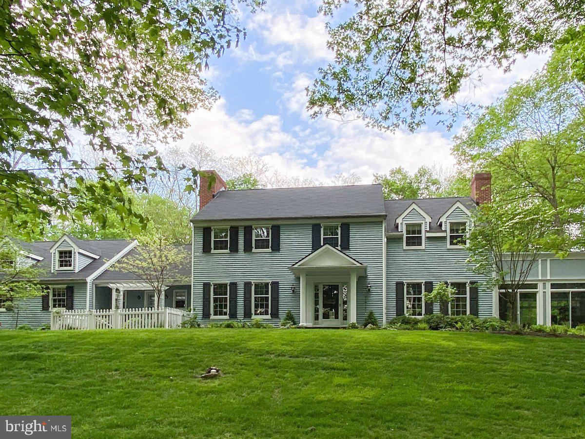Welcome to Wildwood! Nestled on 11+ acres - making it one of the largest properties in New Hope - this exceptional home blends timeless traditional elegance with contemporary additions designed by award-winning architect Ralph Fey. And it's just minutes by foot from the heart of vibrant New Hope. The thoughtfully-designed floor plan is both sophisticated and welcoming. A gracious central foyer sits between the lovely formal dining room that sets the stage for memorable gatherings, and the expansive living room featuring a stunning fireplace with a lovely mantel and stone surround. Off the living room is the grand sun room...an extraordinary space with three walls of windows, high coffered ceiling, a soaring gas fireplace and gorgeous tile floors featuring radiant heat. Here the indoors seems to blend with the extensively landscaped gardens, lawns, and woods. Also accessed through the living room is a bonus space, currently used as a bar, which could be reimagined as a library, office or an extension of the living room. A cozy family room is located off the foyer. Here is a walk-in wood-burning fireplace with an impressive wood beam mantle. French doors lead to the deck which extends across much of the back of the house. The large eat-in kitchen has a decorative fireplace, French doors to the deck, laundry room and garage access, and a walk-in pantry. The main floor also has an updated powder room with a barn-style sliding door. Upstairs are four bedrooms, one of which is currently being used as an office. The primary bedroom features an electric fireplace, sitting area, walk-in closet, dressing area and an updated tile bath. Another outstanding feature of this wonderful home is the other Ralph Fey-designed addition - a suite accessed with its own set of stairs leading from the rear deck. Currently used as a guest suite with a gorgeous tile bath, a full kitchen and an outdoor seating area. The grounds of Wildwood are criss-crossed with woodland paths, hidden seating areas, lush planting beds with flowering shrubs and perennials, several streams enhanced with recirculating pumps and attractive outdoor lighting. The grounds also feature a flagstone patio with a propane fire pit that overlooks waterfalls and the koi pond. Ideal for evening gatherings and watching sunsets. The backyard gardens are protected by an 8 foot deer fence and watered by an extensive sprinkler system. A large cottage-style garden house is ideal for storing equipment, tools and outdoor furniture and games. This extraordinary property is less than one mile from the center of New Hope with its charming shops, fine dining and cultural attractions, and is served by the highly-rated New Hope-Solebury School District. It is close to commuter routes with Philadelphia a 40 mile drive. The Holland Tunnel is a 68 mile drive. This is truly a remarkable offering in an unparalleled setting.