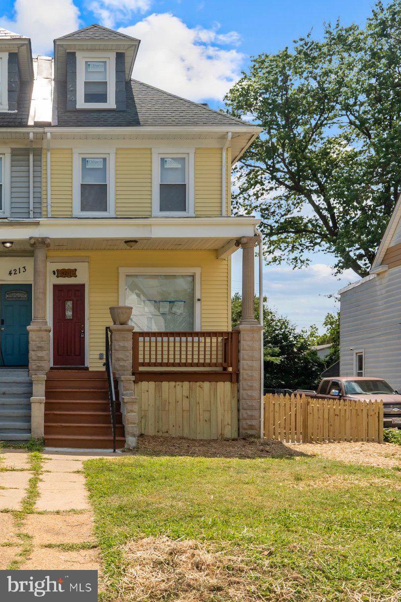 Newly renovated 5BR/3.5BA semi detached Colonial style home located on a tree-lined street.   Make your way to the covered front porch of your forever home which offers four floors of living space.  Open the door and step inside to a home filled with natural light, luxury flooring, recessed lighting, an open concept main floor plan, and a soft color palette.  The main floor boasts a large living room open to the dining room, a half bath, and a brand new kitchen.  The kitchen features mixed metals consisting of gold, black and stainless, [plenty of cabinets finished with crown moldings, stainless steel appliances, a deep stainless sink, and a sleek quartz countertop.  On the second floor are two sizable secondary bedrooms, a large primary sized bedroom, and a newly renovated full bath with gold accents and tile from ceiling to tub.  There is a third floor that offers a large owners suite bedroom and a private full bath with a walk-in shower.  The lower level is finished hosting the fourth bedroom, a full bath with a walk-in shower and bench seating, a spacious countertop kitchen ideal for extra potential rental income , a room ideal as a home office or child's play room, and access to the fenced yard.  From the kitchen step outside onto a covered wood deck with newly replaced railings and stairway, which overlooks a spacious yard  and parking pad filled with so many possibilities.  This home is move-in ready, ideal for any new homeowner, and is located in close proximity to shopping, restaurants, and commuter routes.